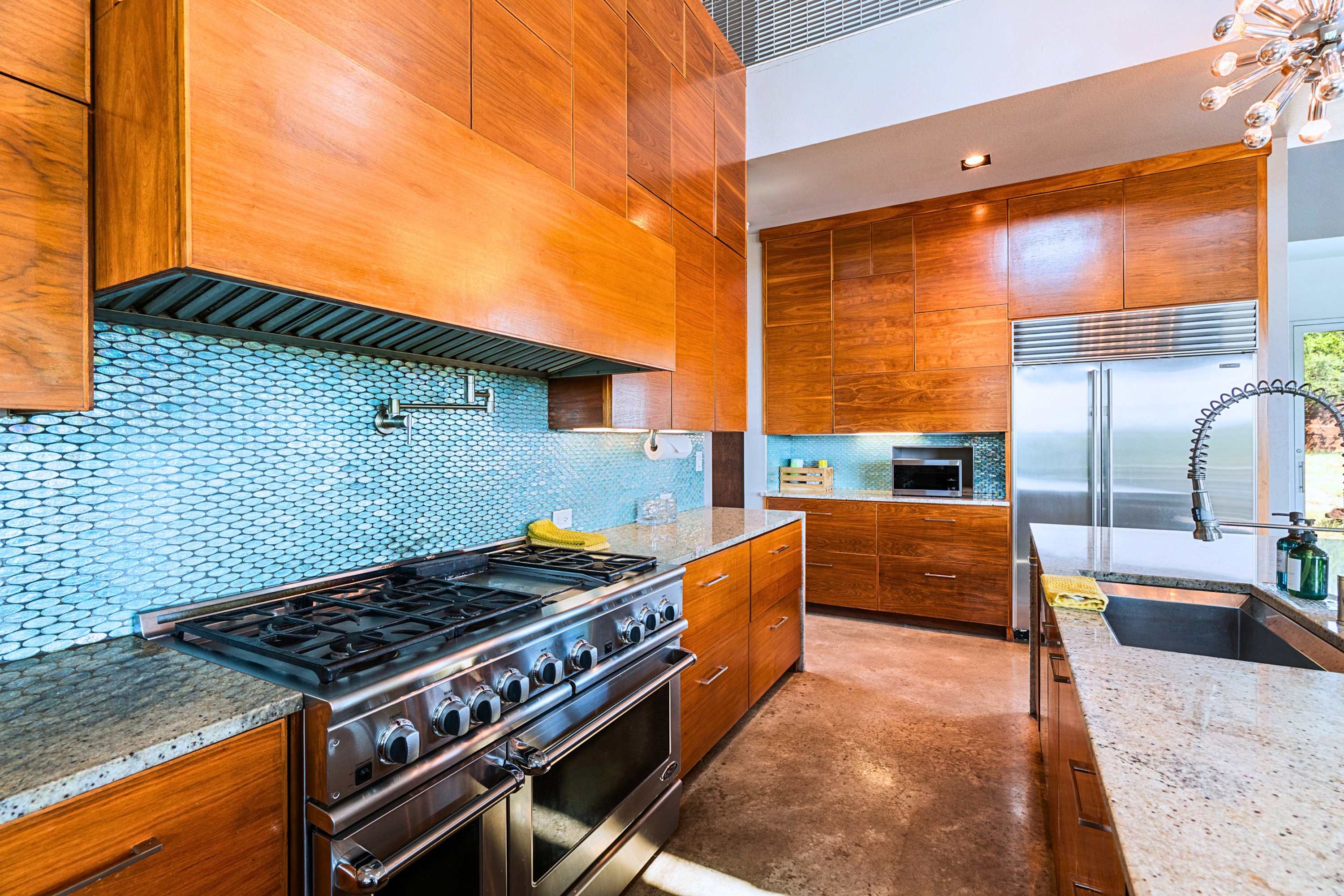 Main: High-end culinary space featuring a premium pro-grade gas range and luxury finishes.