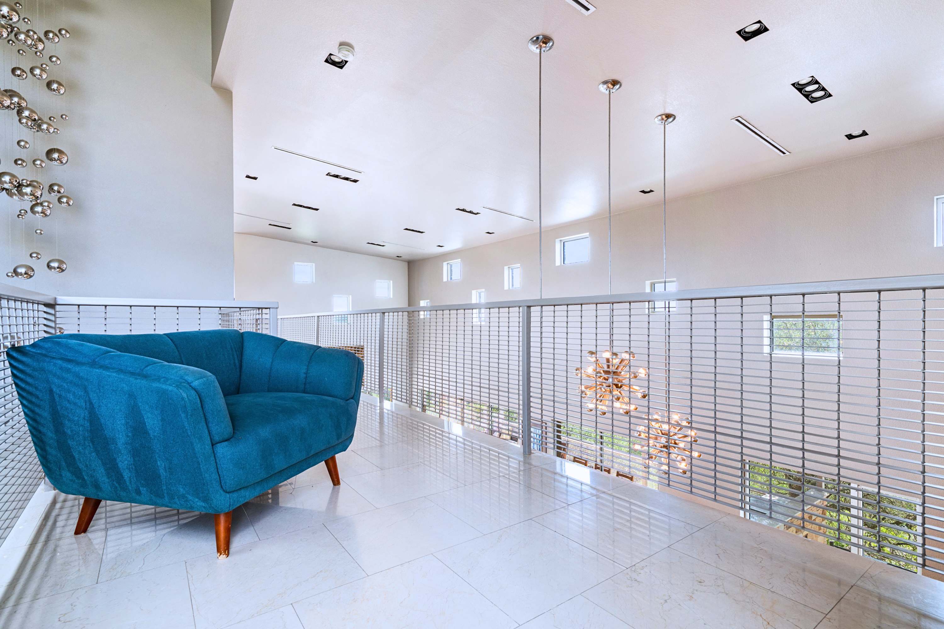 Main: A quiet upstairs retreat featuring chic seating, perfect for reading or relaxing.