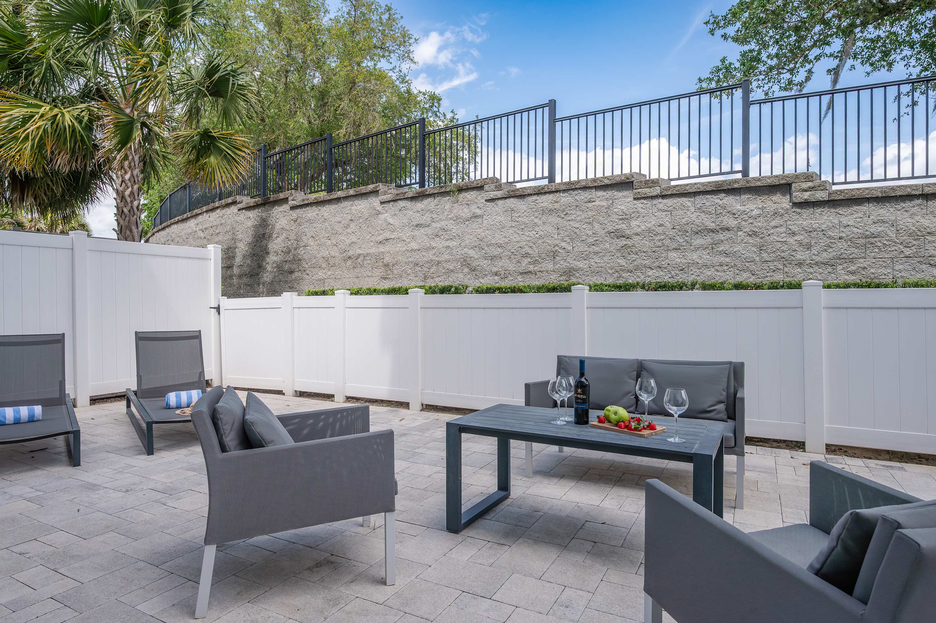 Outdoor patio with modern seating and a table set for wine and snacks