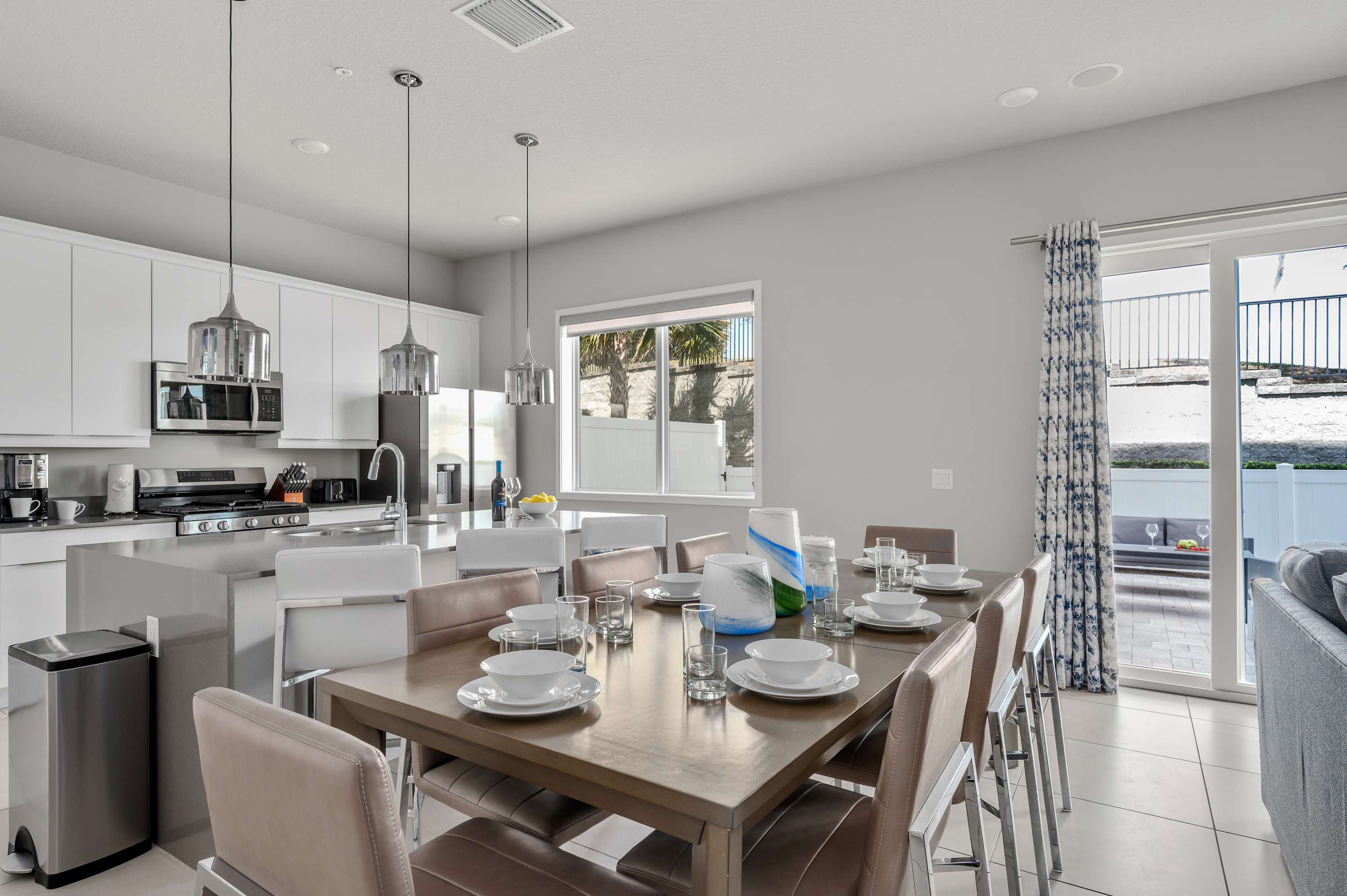 Modern kitchen and dining area with seating for ten and natural light from large windows