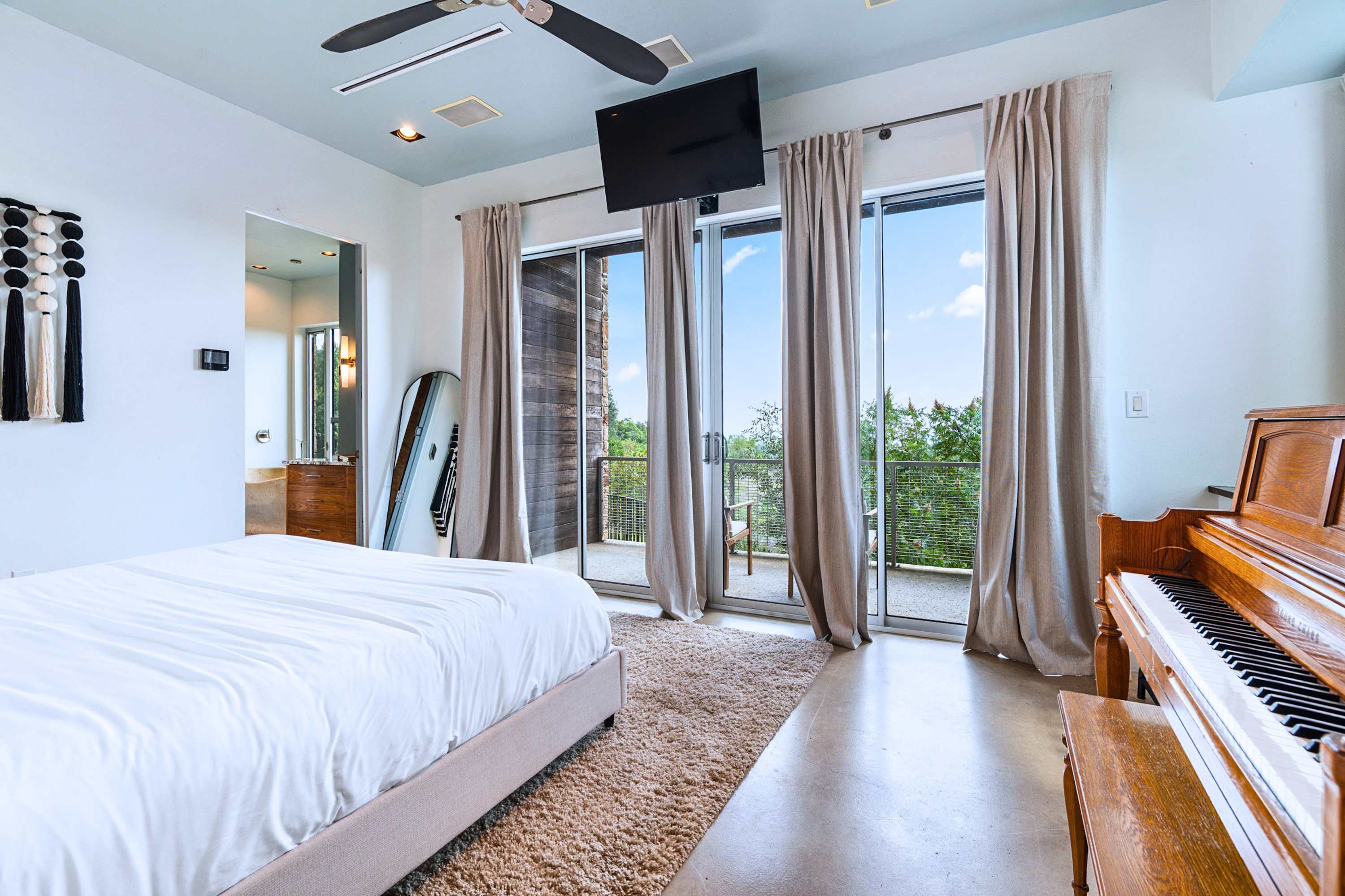 Main: Wake up to panoramic treetop views from the floor-to-ceiling glass doors.