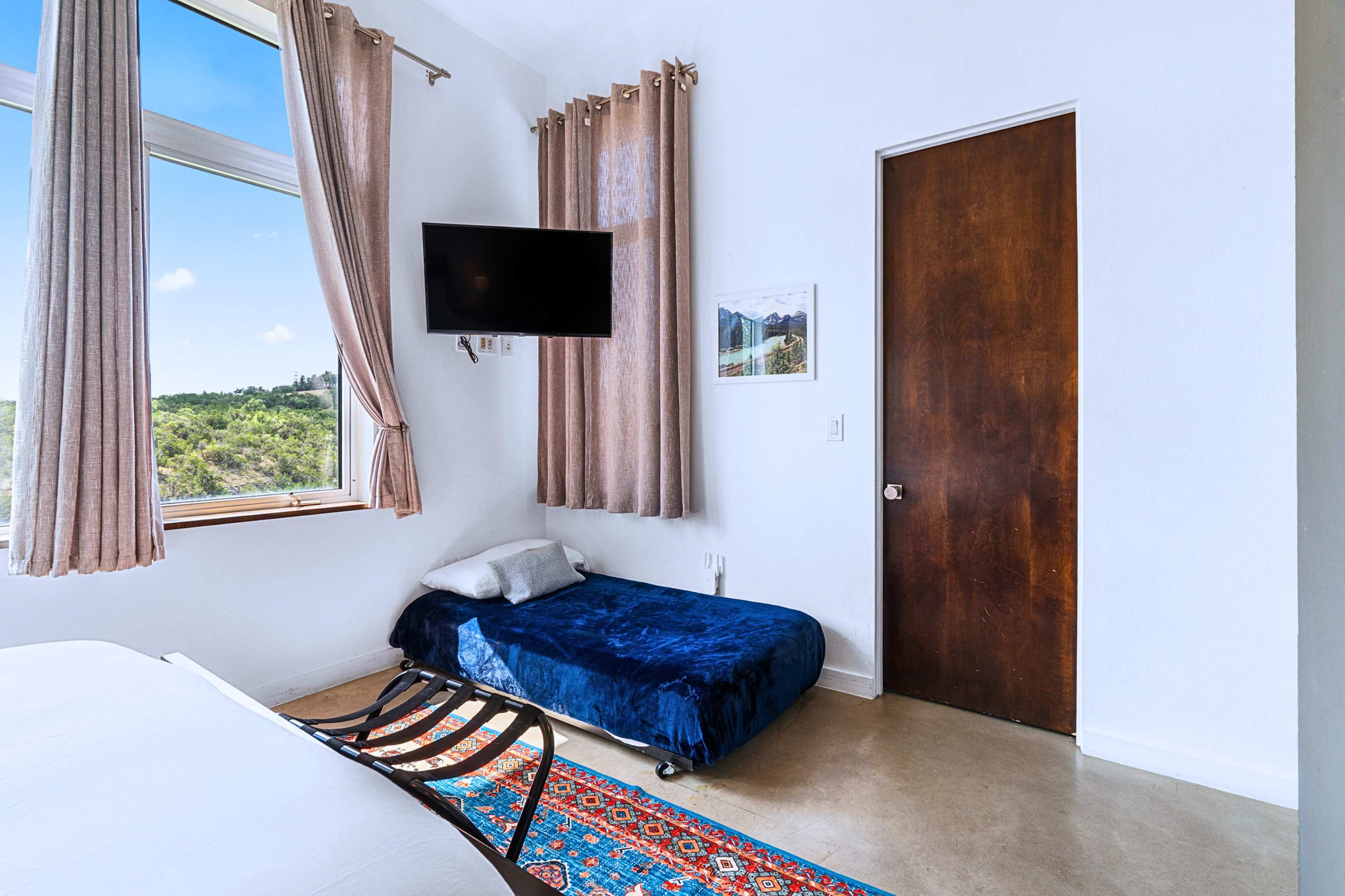 Main: A peaceful guest room offering a cozy nook and plenty of beautiful natural light.
