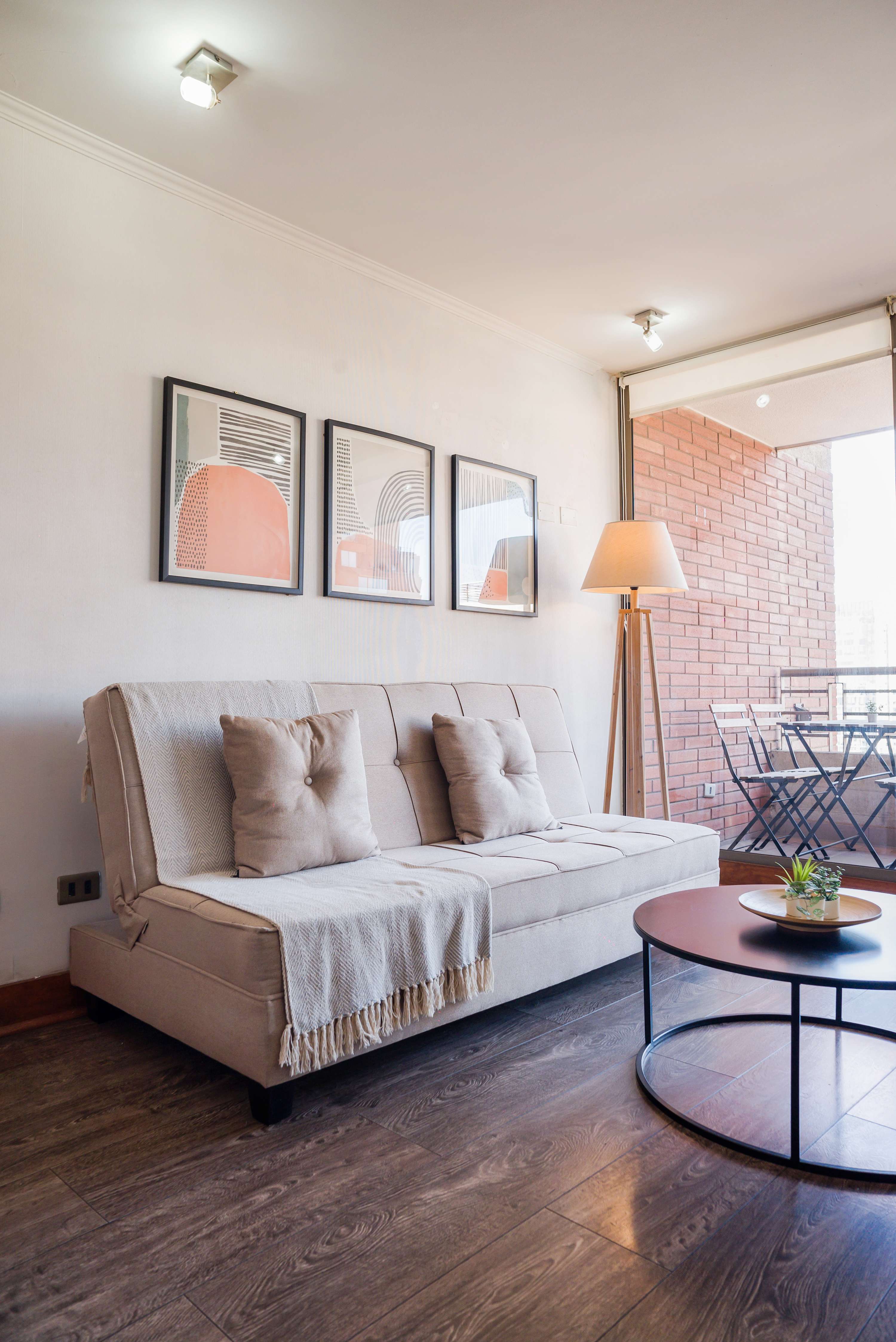 Relax in this stylish living area with a comfy sofa and access to a charming balcony, perfect for unwinding after a day of exploring.