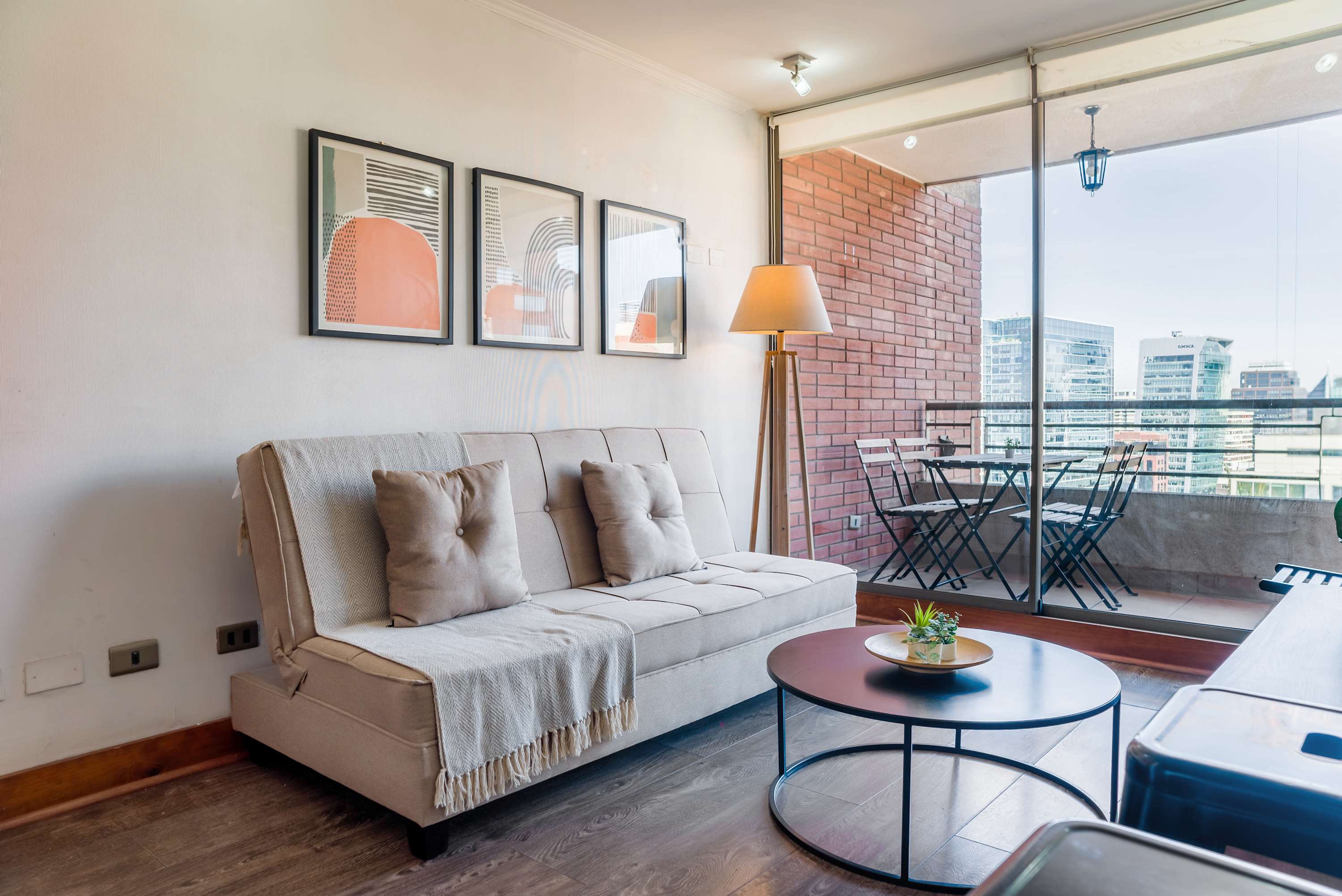 Enjoy city views from this stylish living room with a cozy sofa and private balcony.