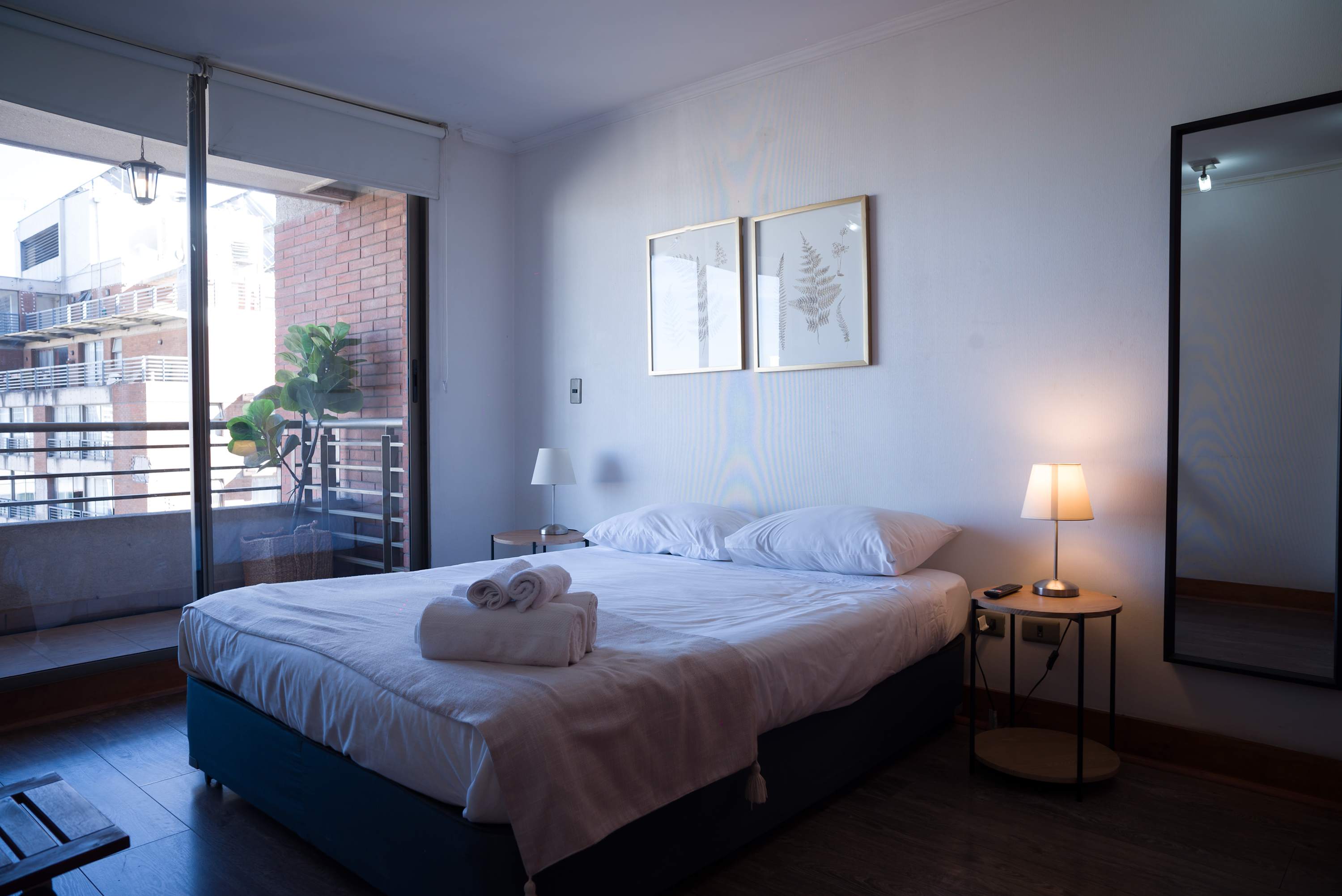 Cozy bedroom with a private balcony offering city views, perfect for unwinding after a day of exploring.