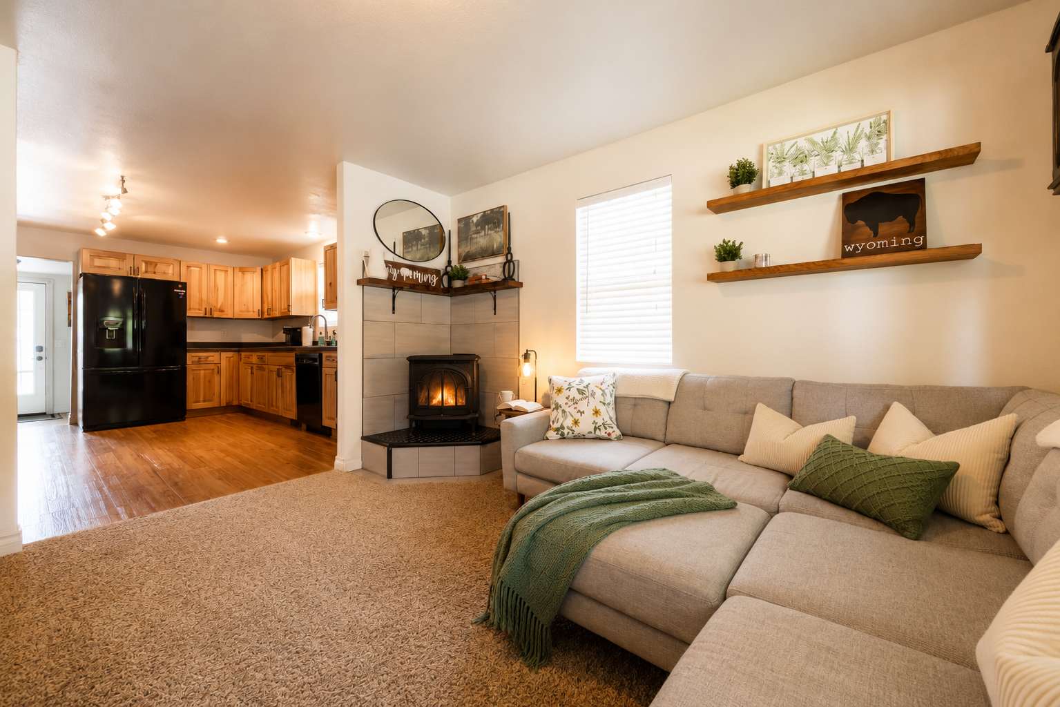 Spacious living room at The Maple with sectional sofa, fireplace, and open kitchen — Sheridan, Wyoming