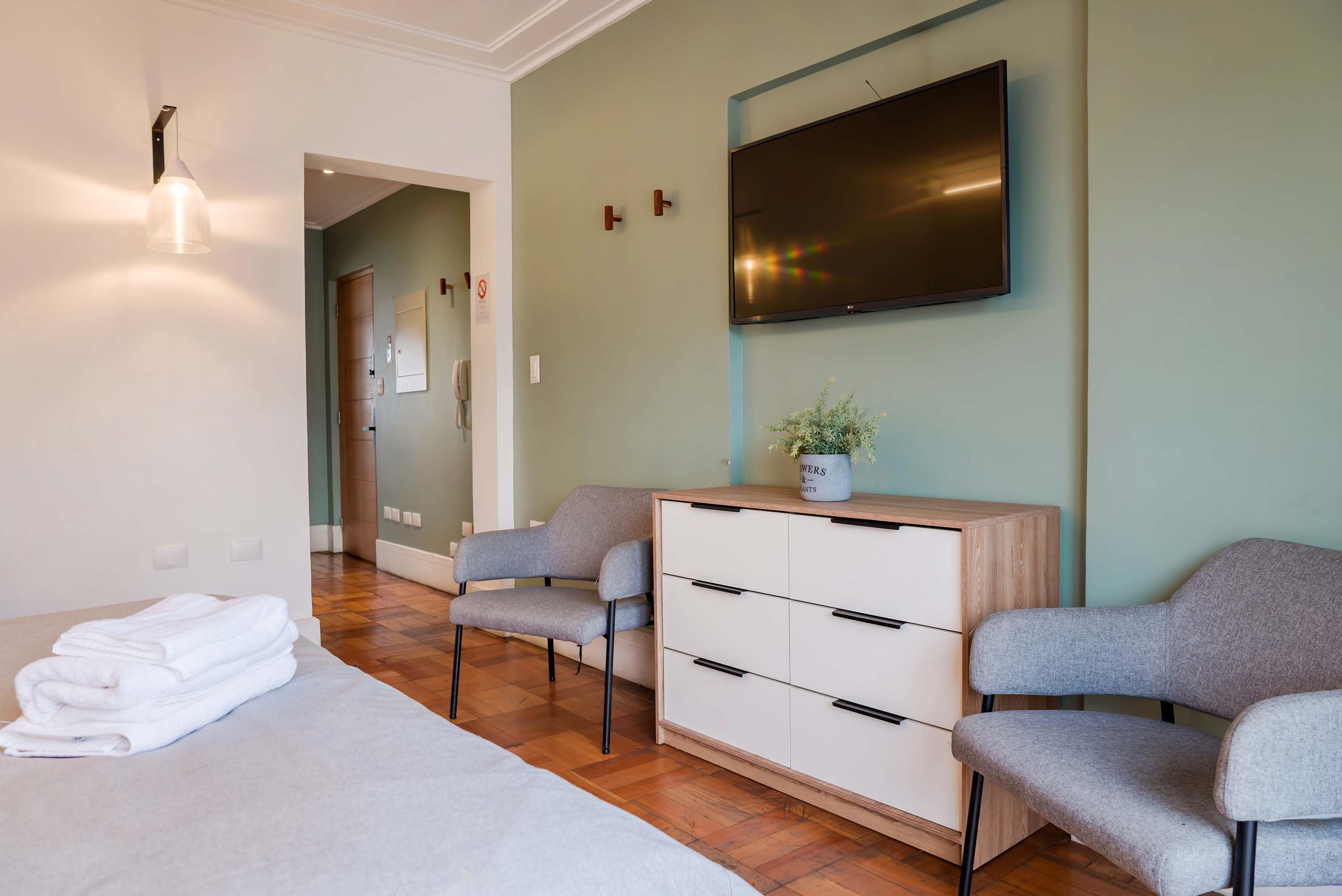 Relax in this cozy living area with a wall-mounted TV and stylish seating, perfect for unwinding after a day of exploring.