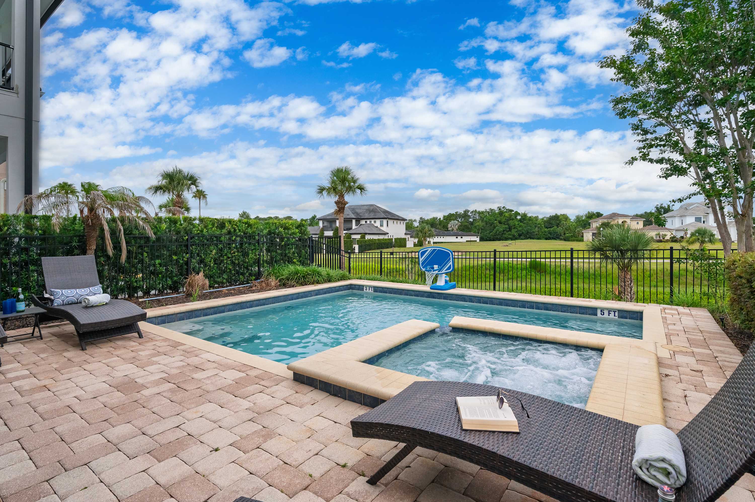Relax by the pool and spa with views of the open green landscape.