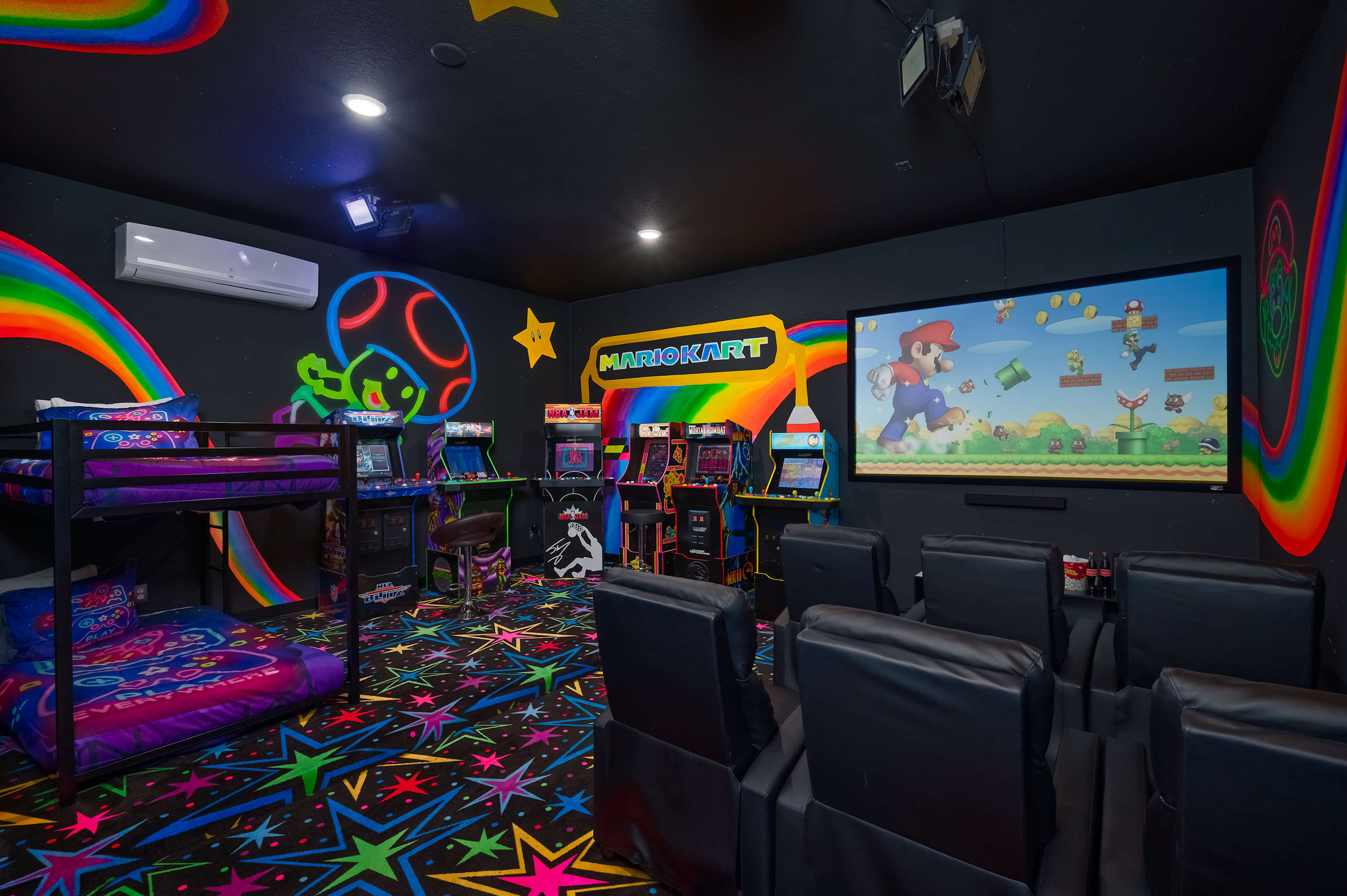 Family-friendly game room featuring classic arcade machines and a large screen for video gaming.