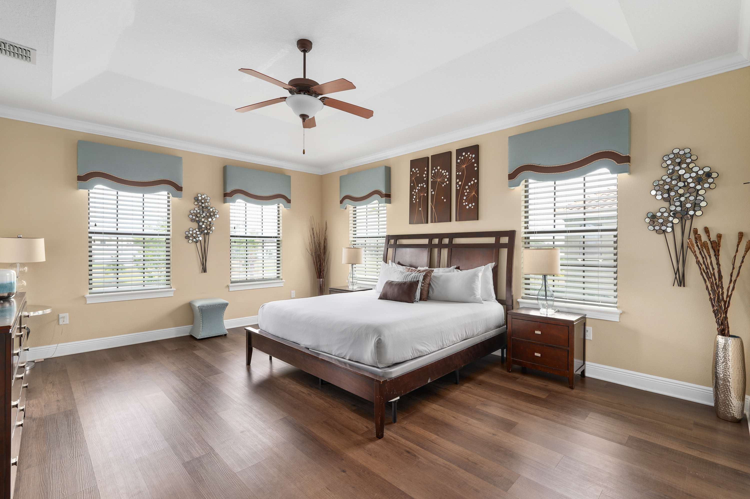 Spacious bedroom with natural light, wood flooring, and modern decor for a relaxing stay.