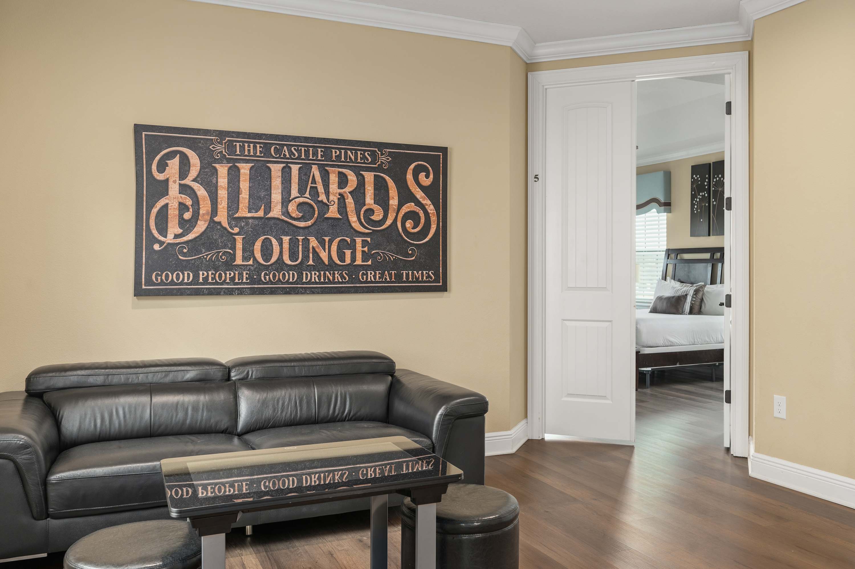 Relax in the modern lounge area with leather seating and a view into the cozy bedroom.