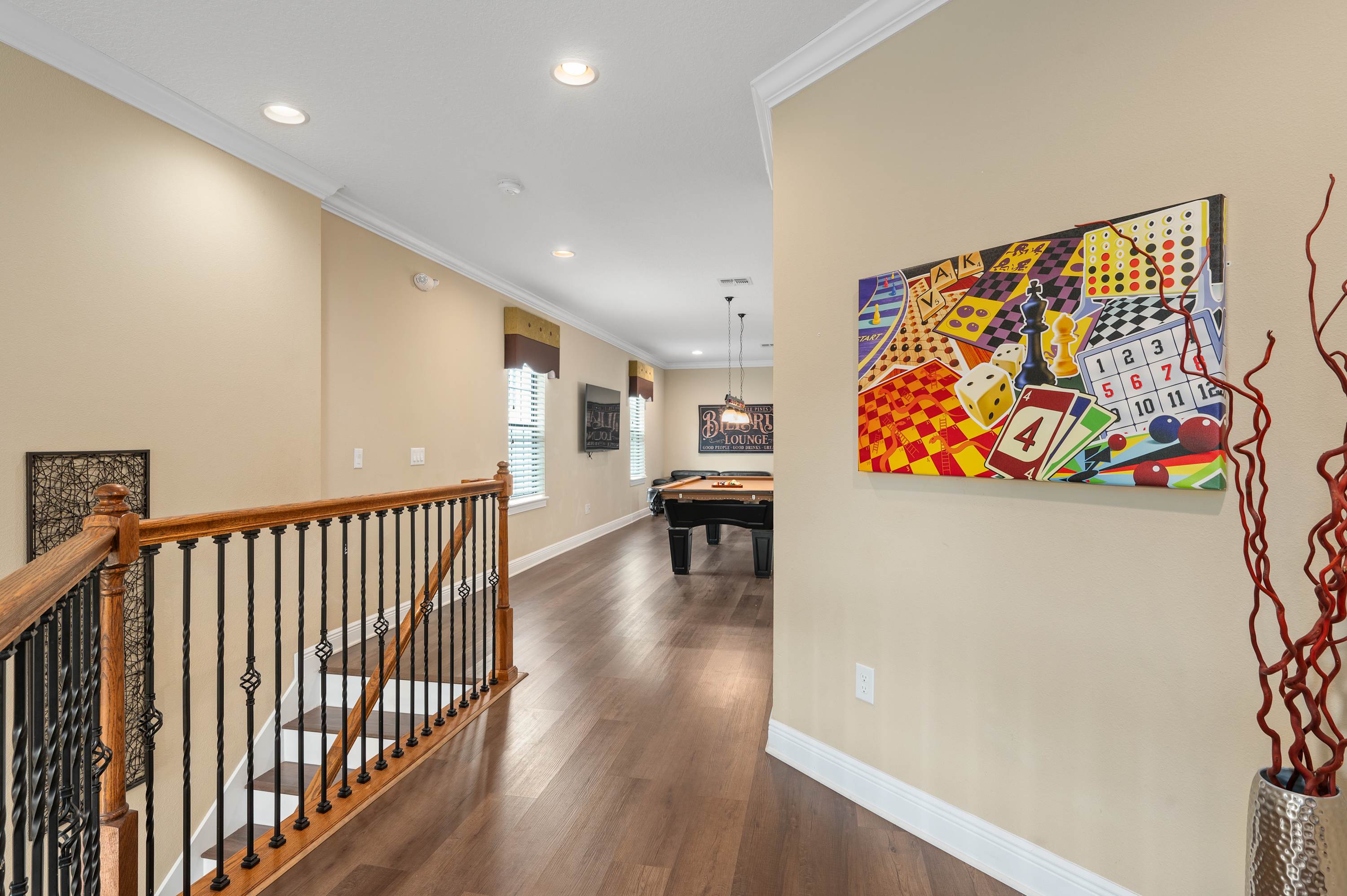 Game room with pool table and colorful wall art in a bright, open space.