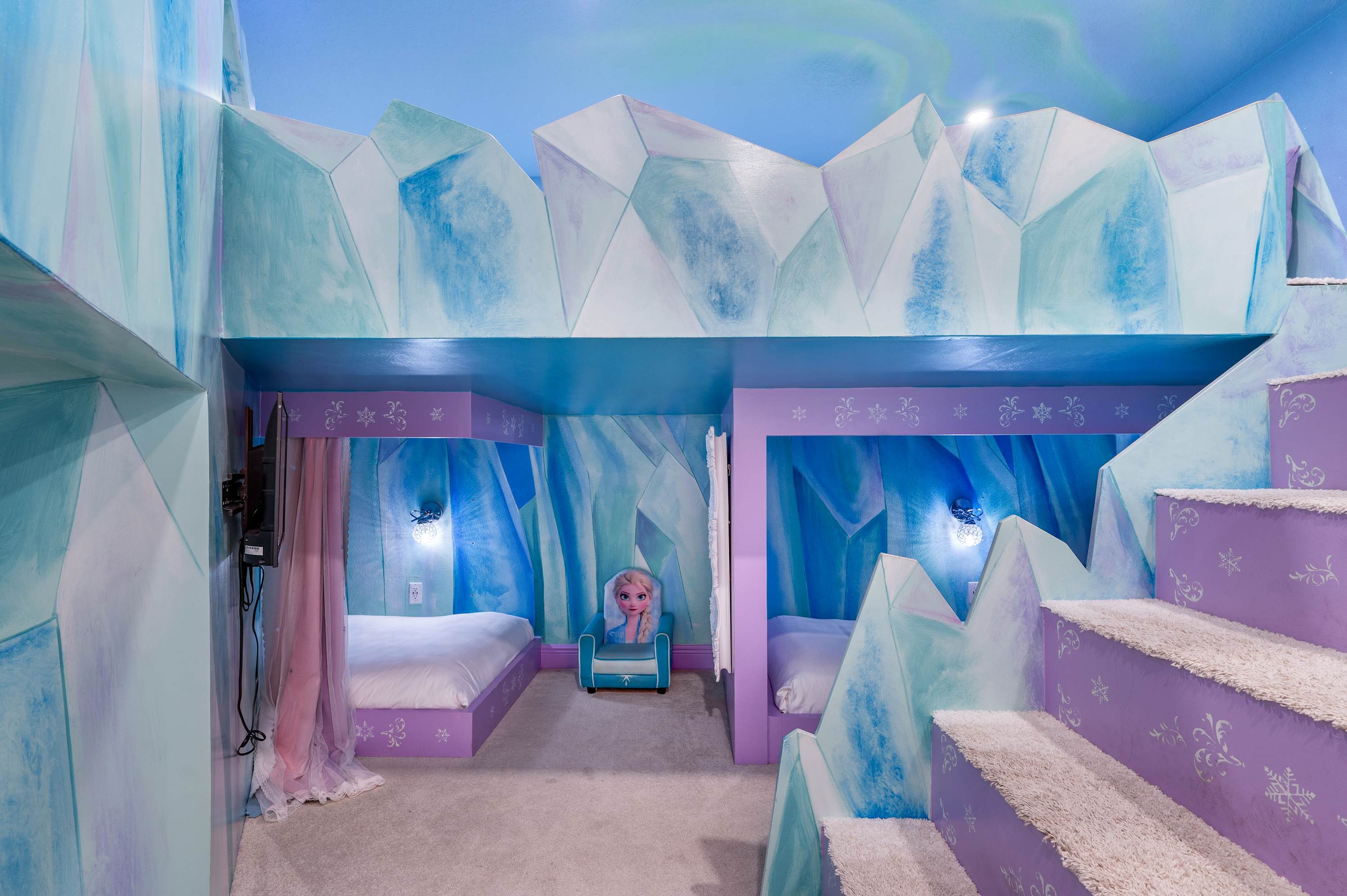 This themed bedroom features icy blue and purple decor with built-in beds and a character chair for a playful atmosphere.