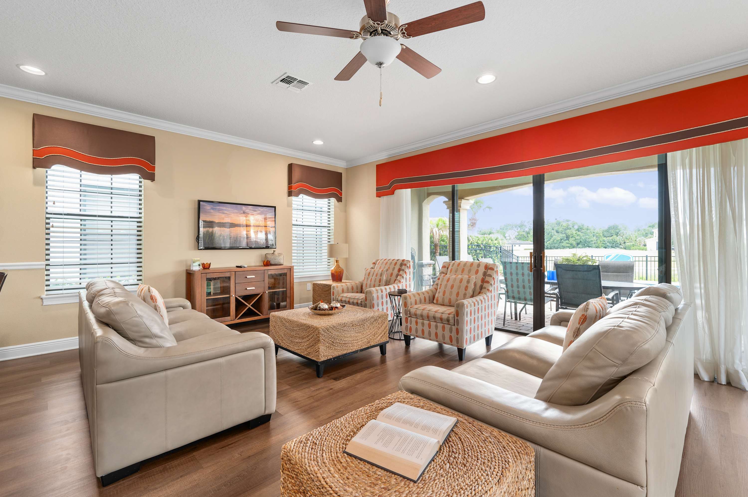 Spacious living room with leather sofas and sliding doors opening to a patio.