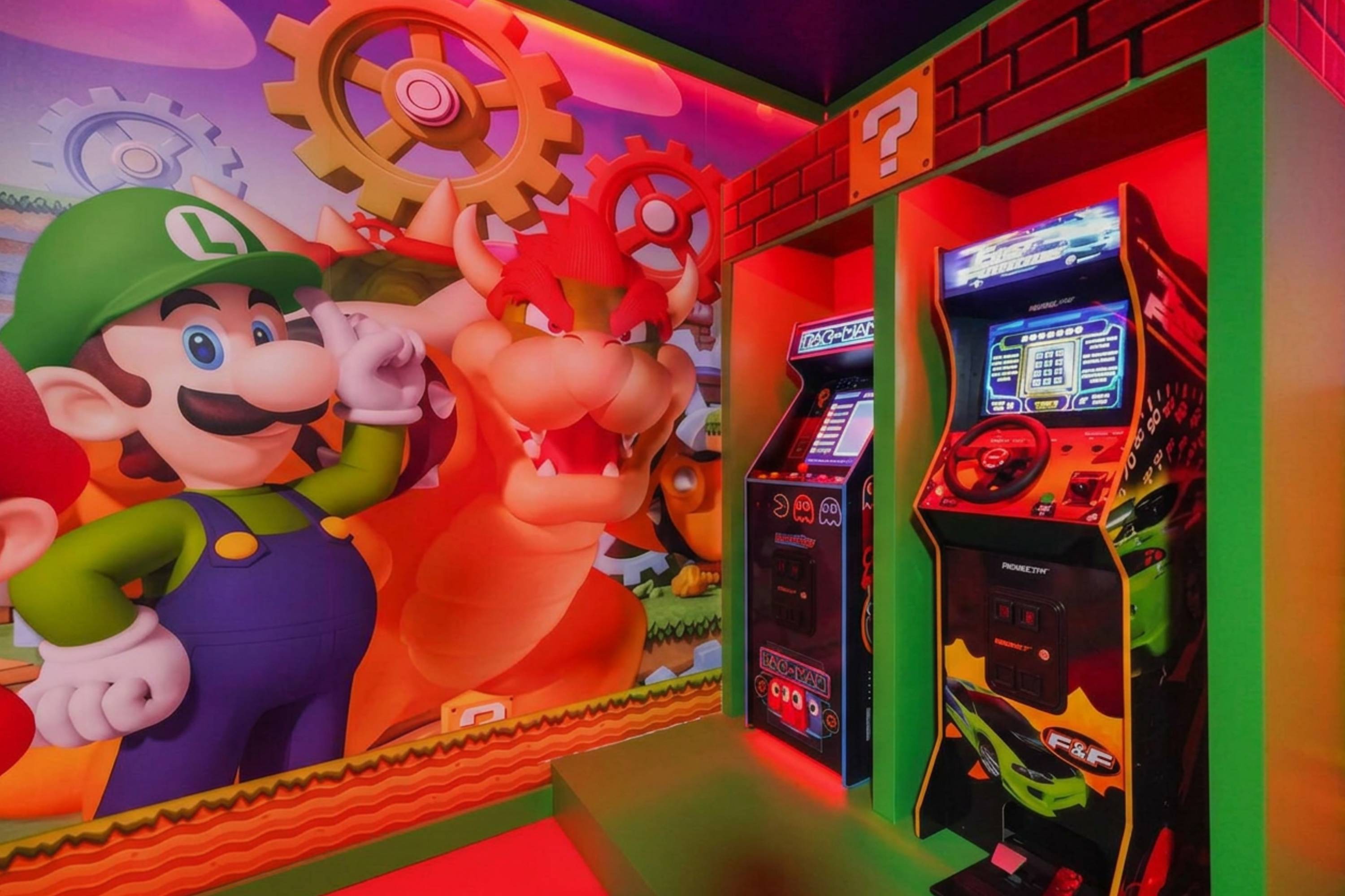 njoy arcade fun with friends and family in the Mario and Luigi themed game room featuring foosball, game consoles, and lounge seating