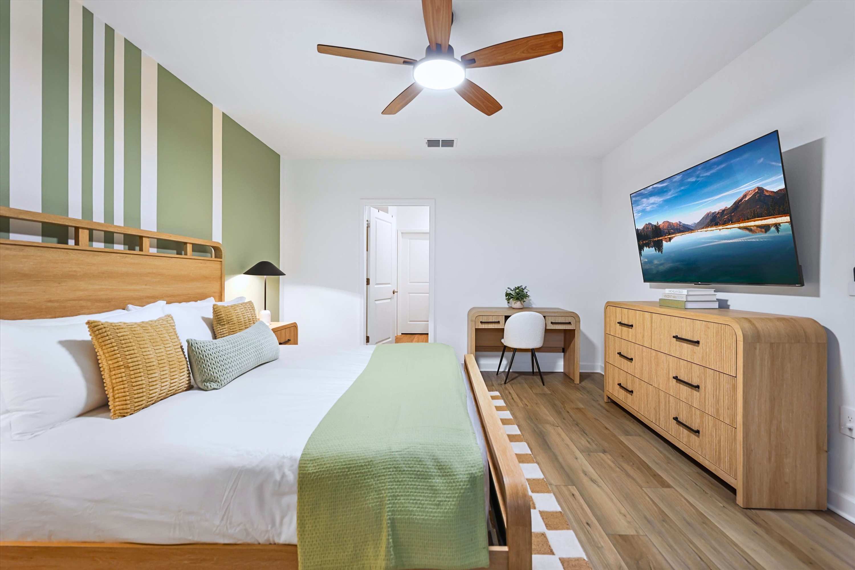 Unwind in the spacious king bedroom featuring a Smart TV and ceiling fan