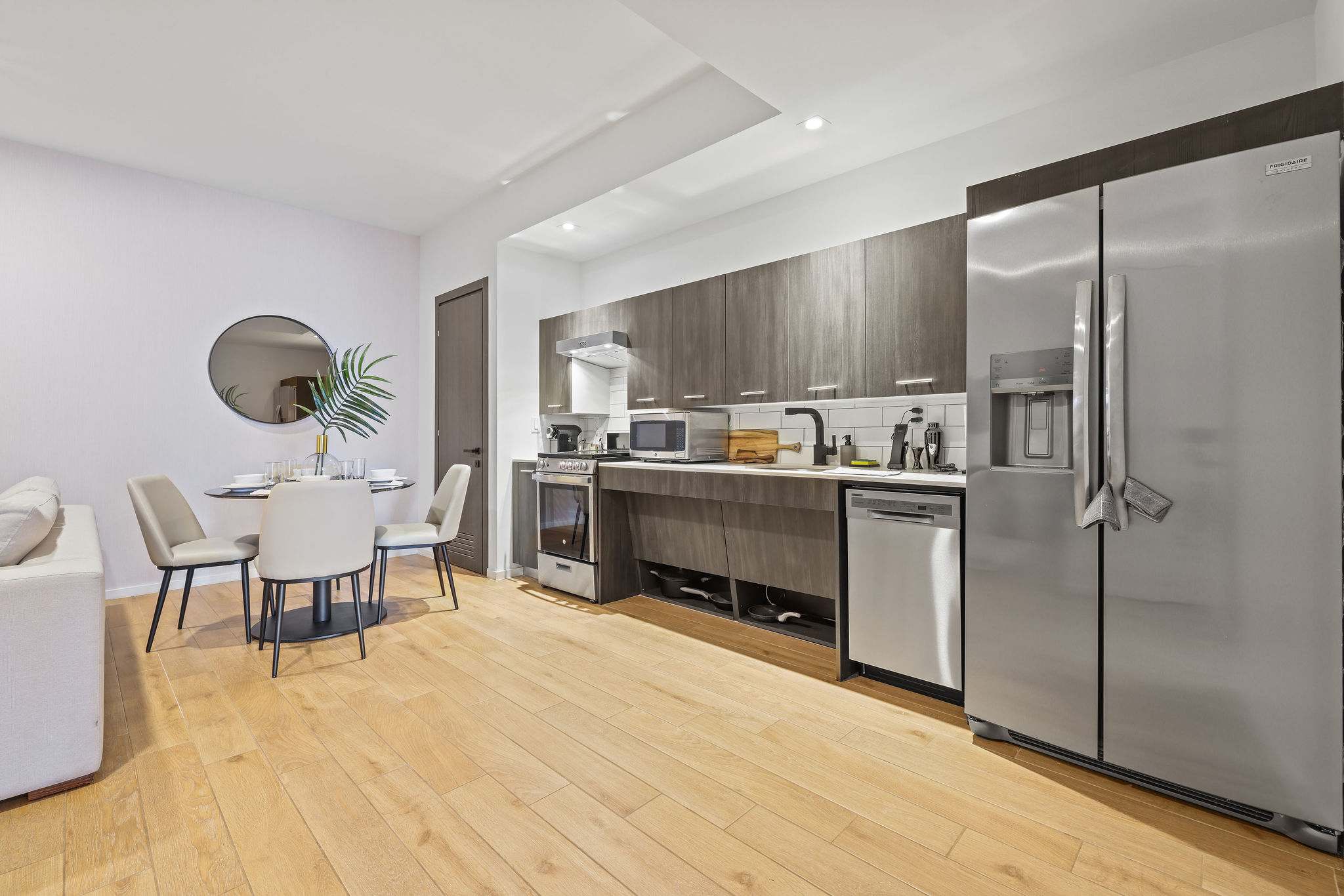 Sleek and modern kitchen with stainless steel appliances and a cozy dining area perfect for intimate meals.