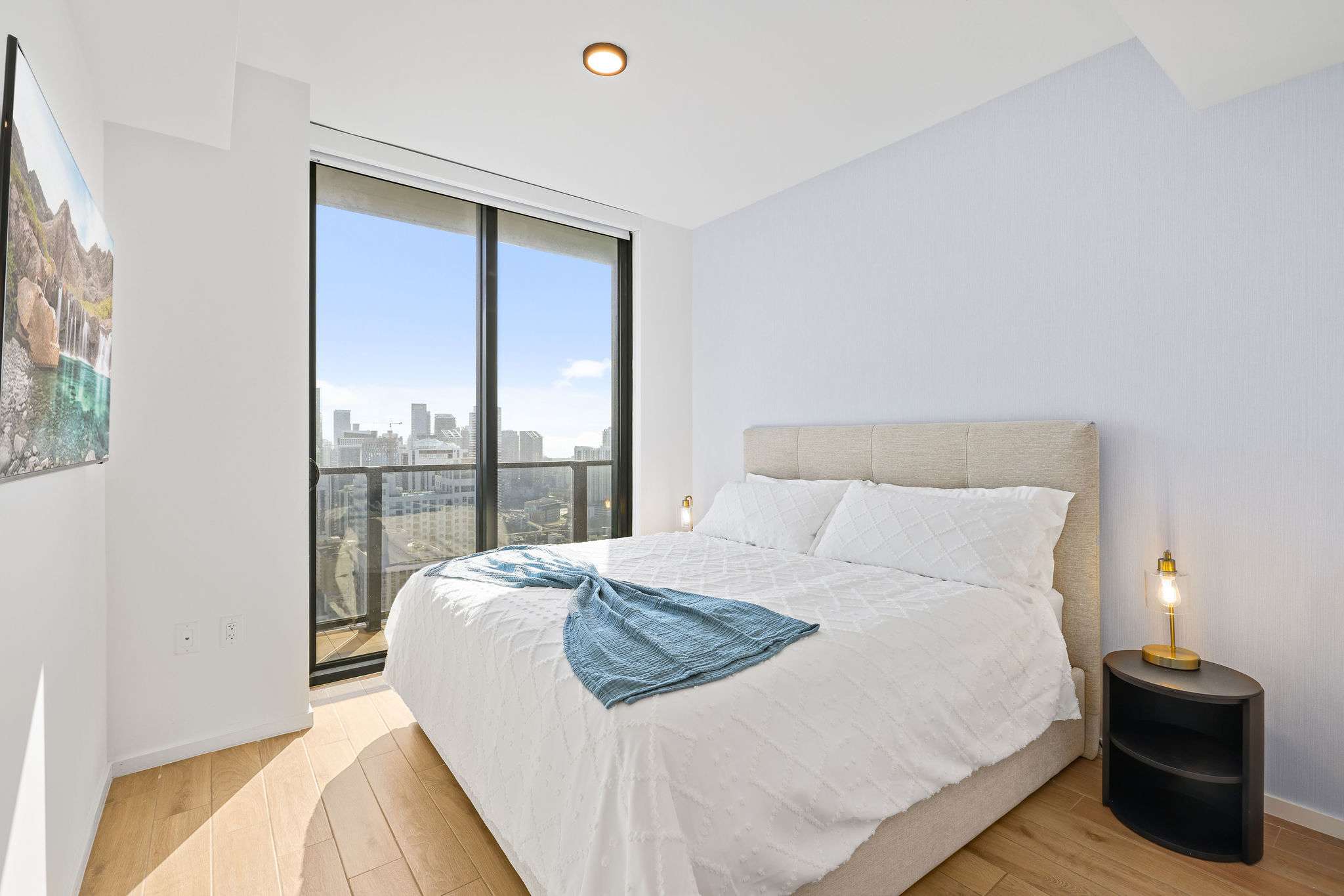 Relax in this bright bedroom with stunning city views and modern decor, perfect for a cozy stay.