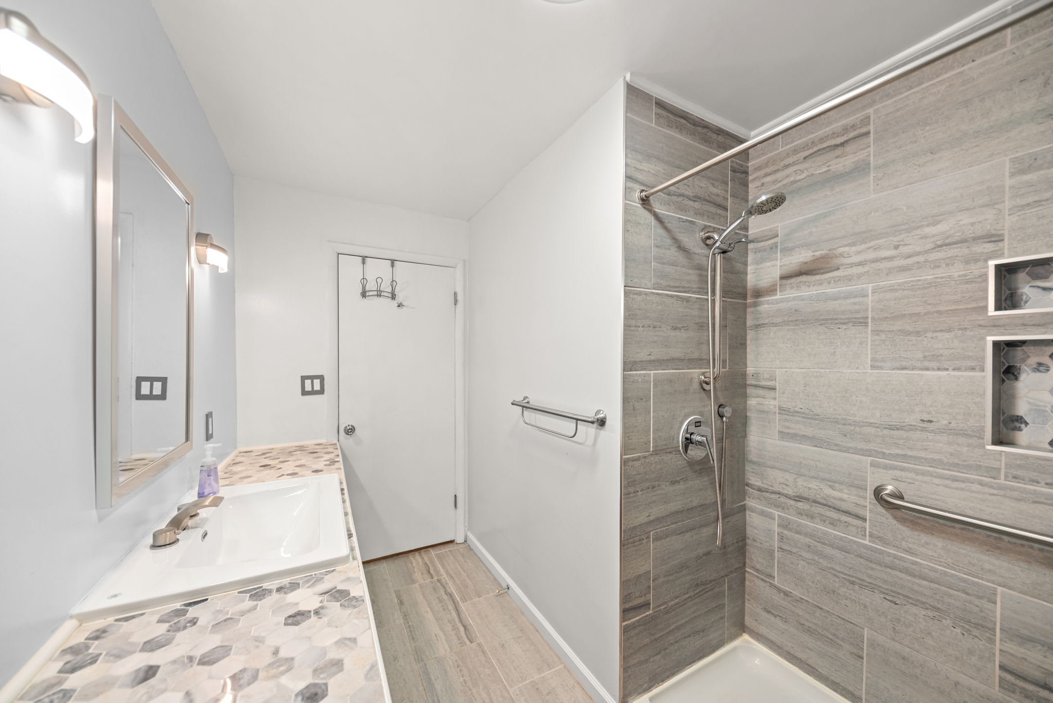 Walk in shower with grab bars offers added comfort and convenience.