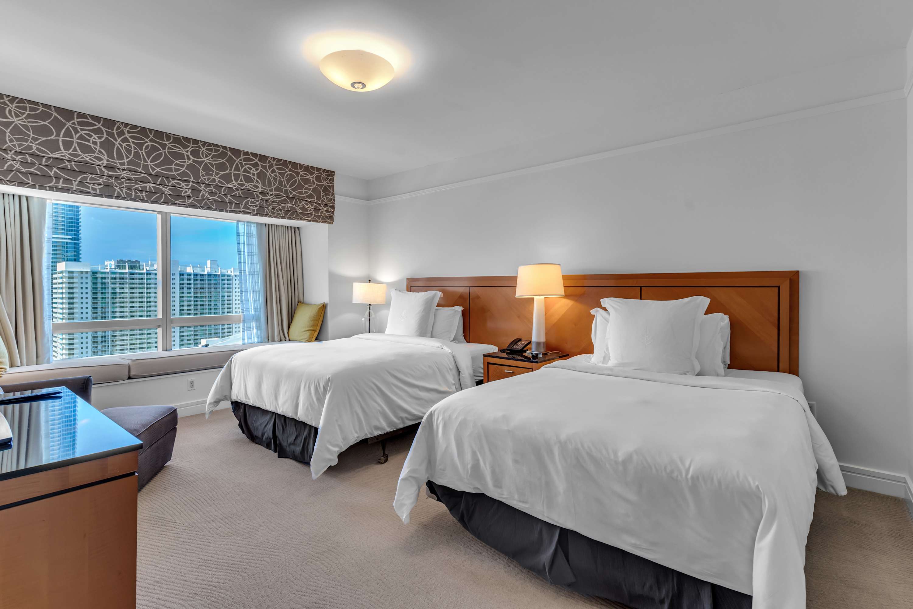 The second bedroom offers a pair of plush queen beds, a smart TV, & an ensuite​