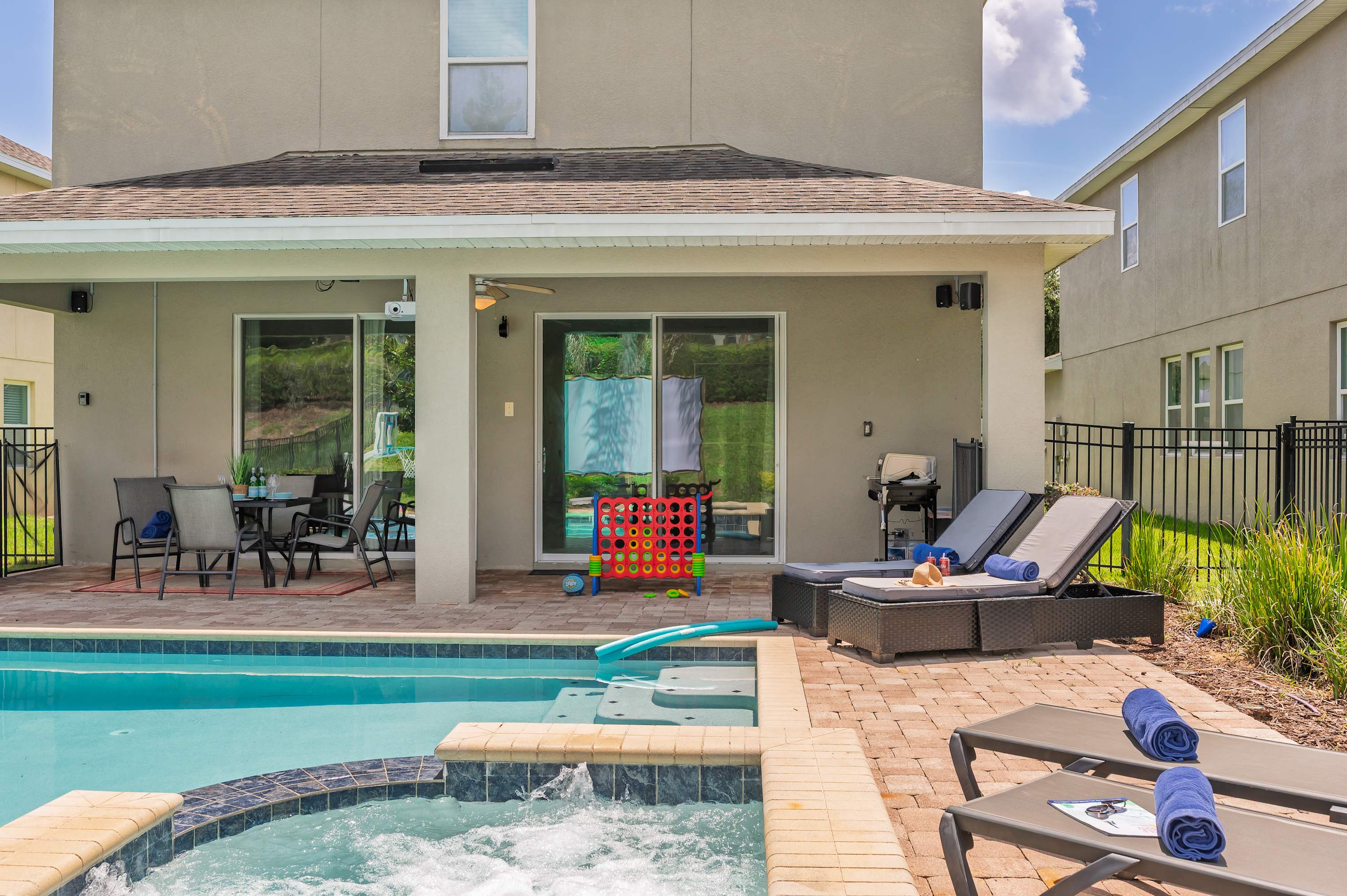 Relax by the poolside with lounge chairs and a covered patio area for outdoor dining and games.