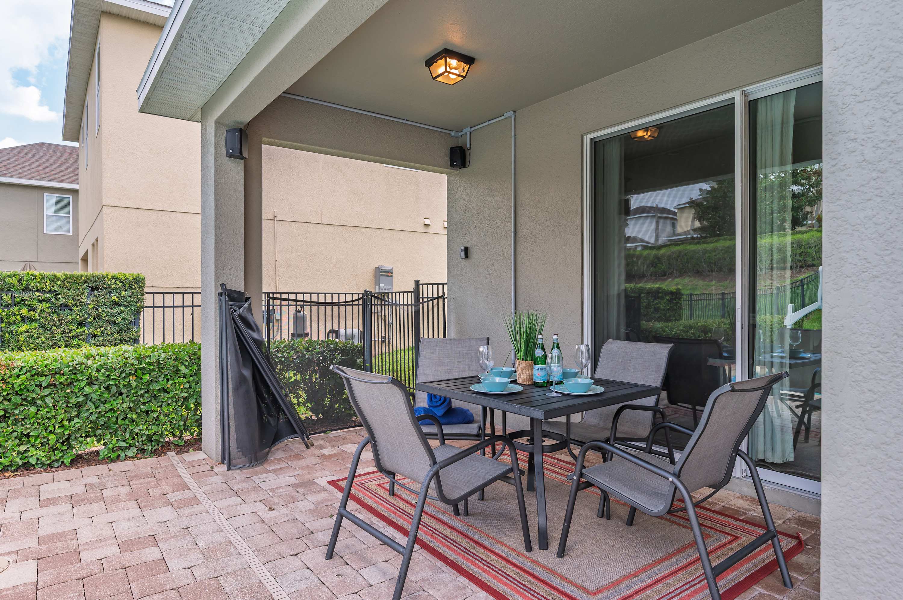 Covered patio with outdoor dining set and garden views for relaxing meals.