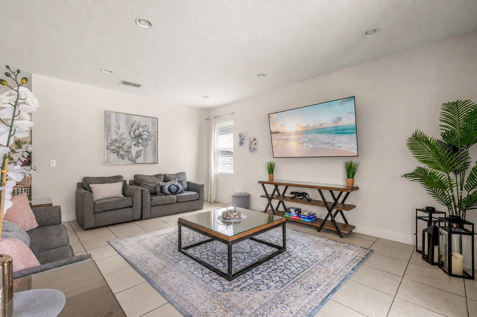 Modern living room with comfortable seating and a large wall-mounted television.