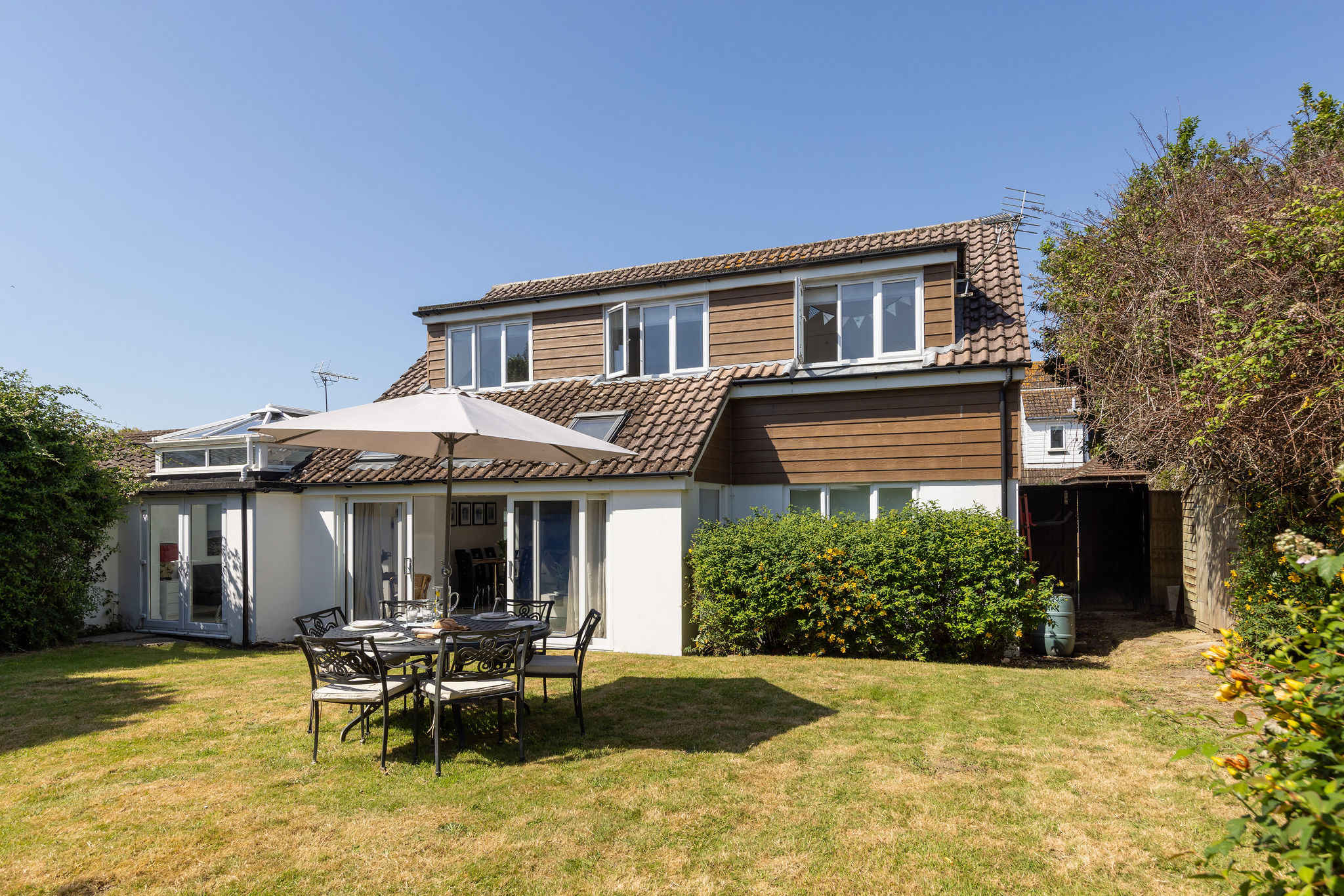 Relax under the parasol in the peaceful outdoor space of this charming seaside property.