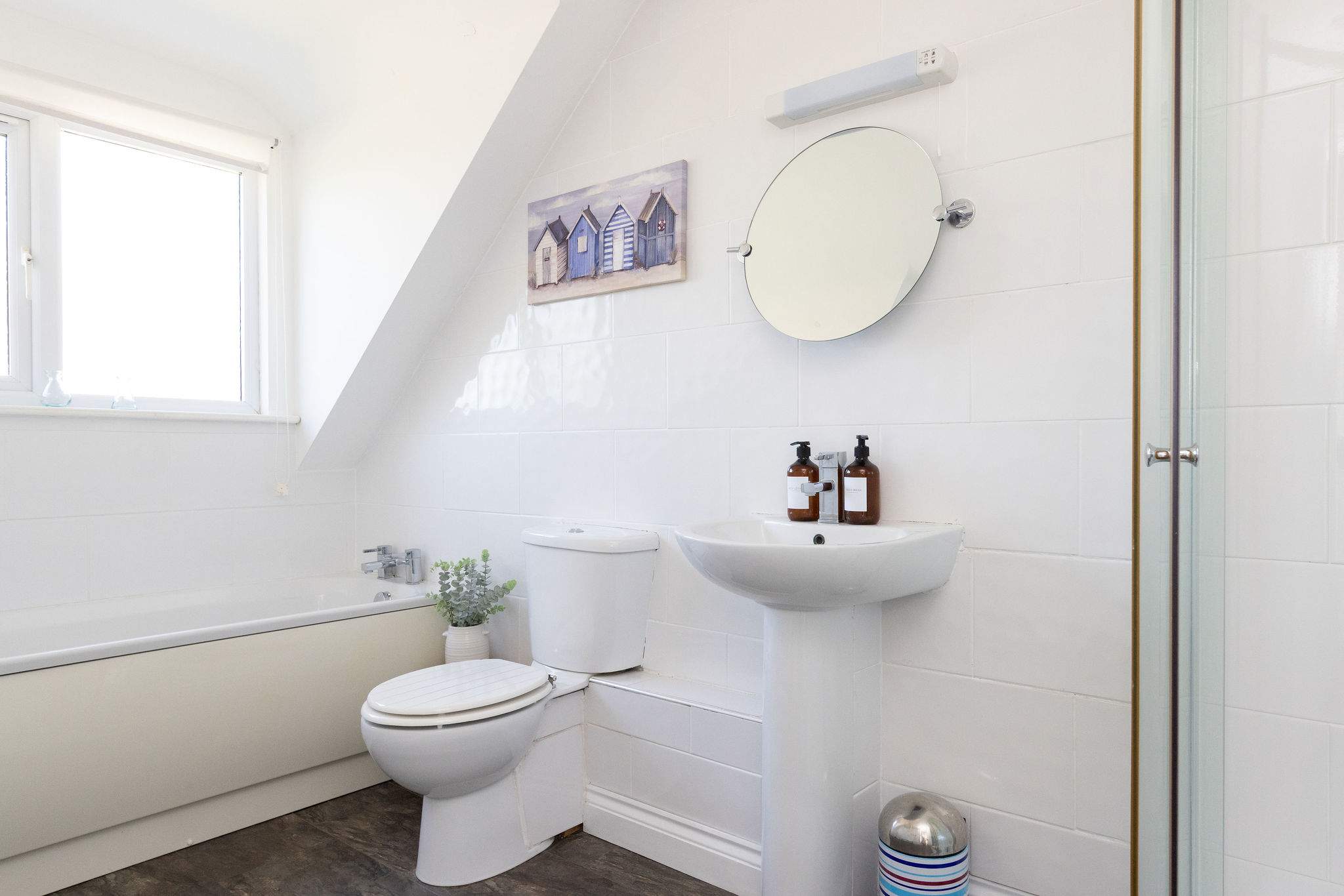 Freshen up in the bright family bathroom featuring both a relaxing bath and modern shower.