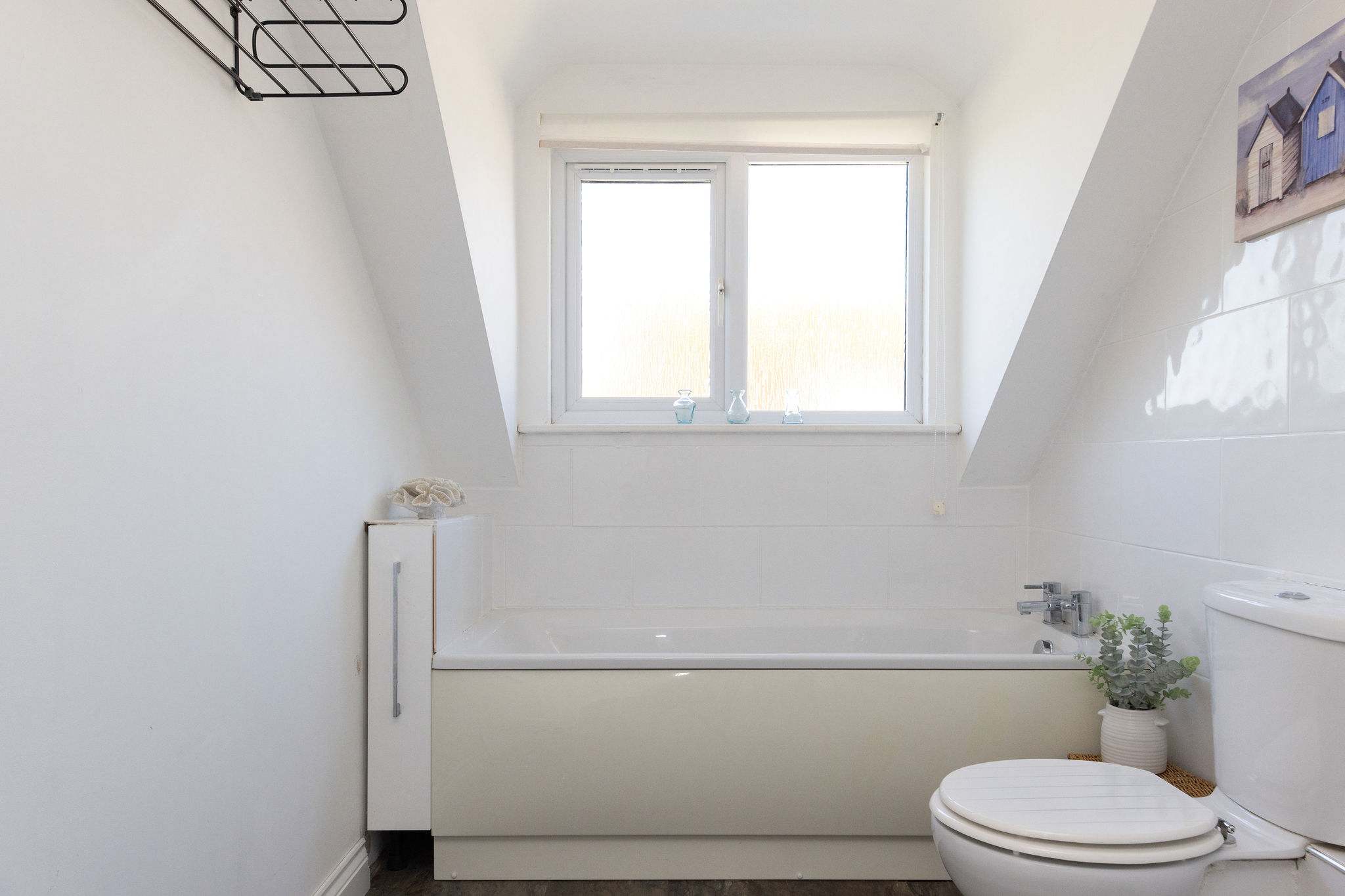 Enjoy a soothing soak in the bright family bathroom of our relaxing coastal retreat.