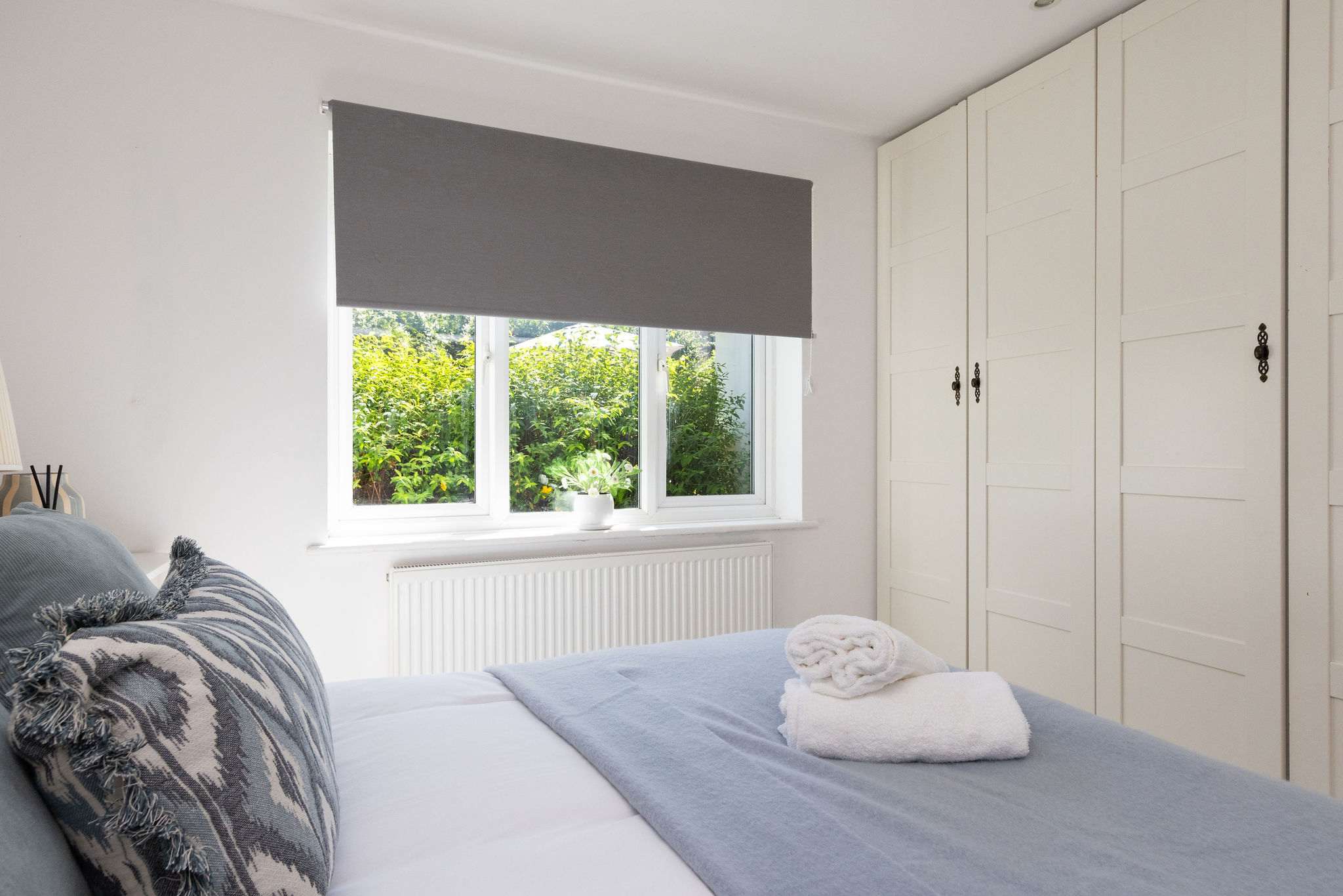 Wake up to tranquil garden views in the spacious master bedroom of our holiday home.