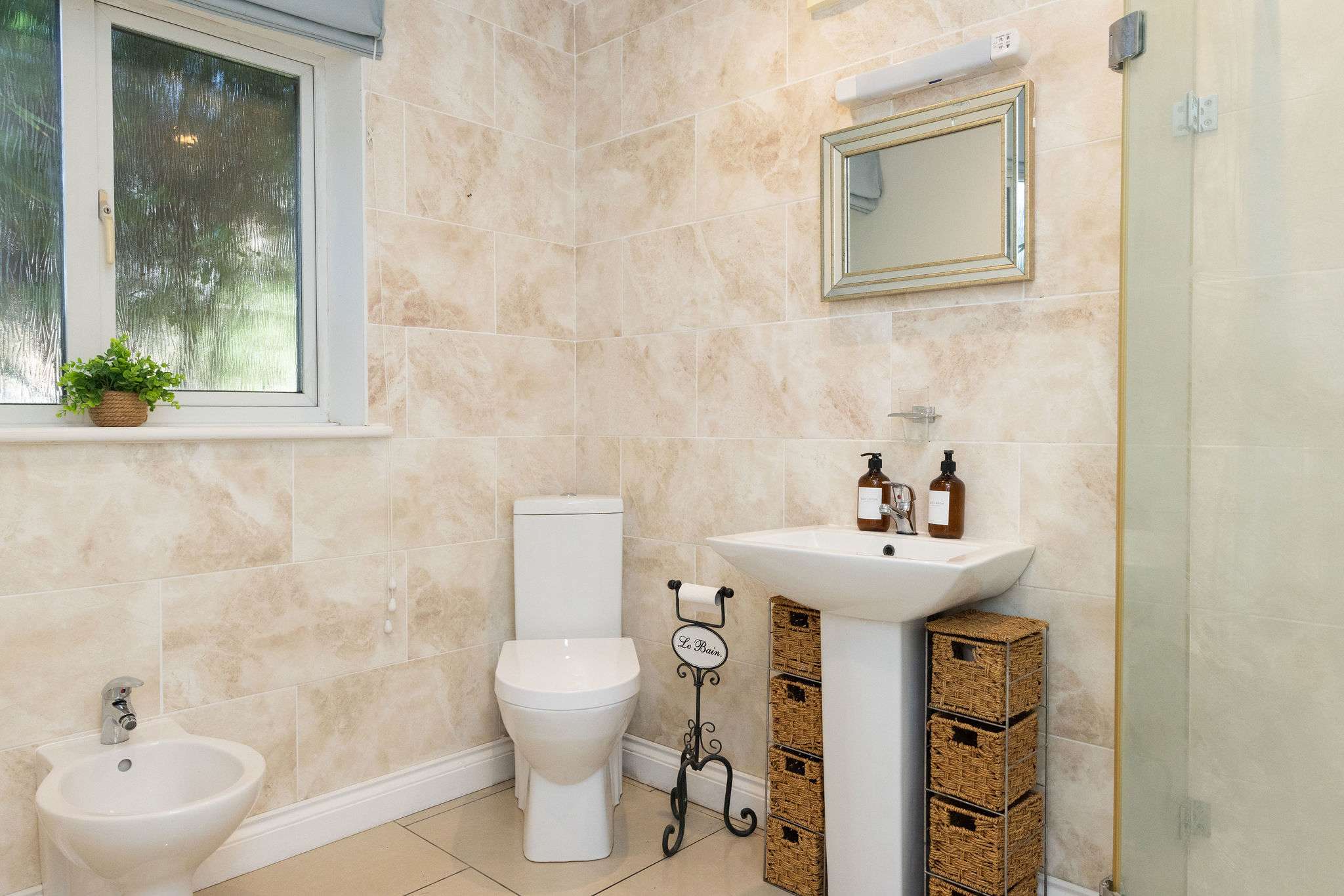 Appreciate the elegant stone tiling in the second modern bathroom of your family getaway.