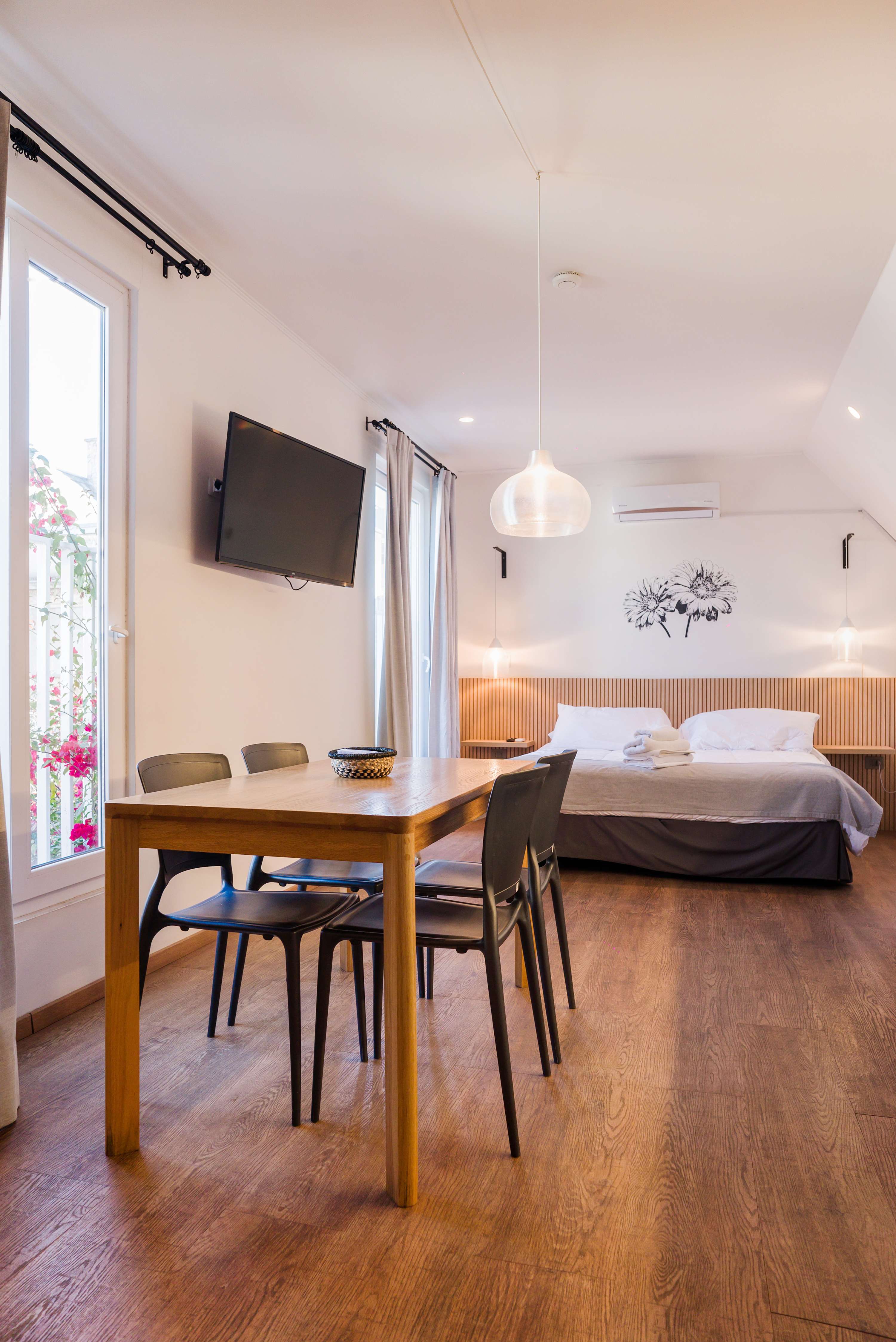 Cozy studio with modern furnishings, natural light, and a comfortable dining area perfect for a relaxing stay.