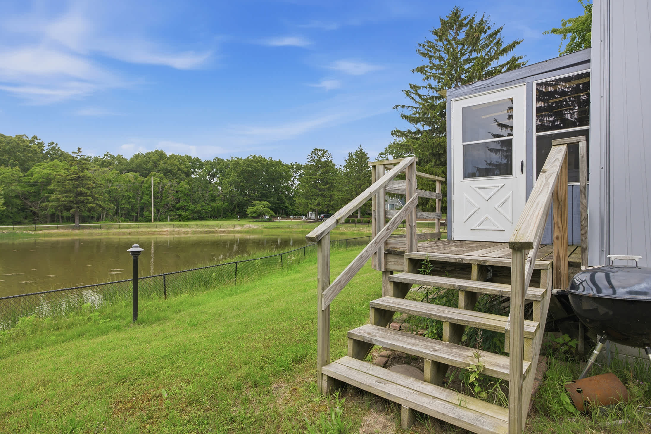 Private outdoor entry opens to scenic pond views and green space.