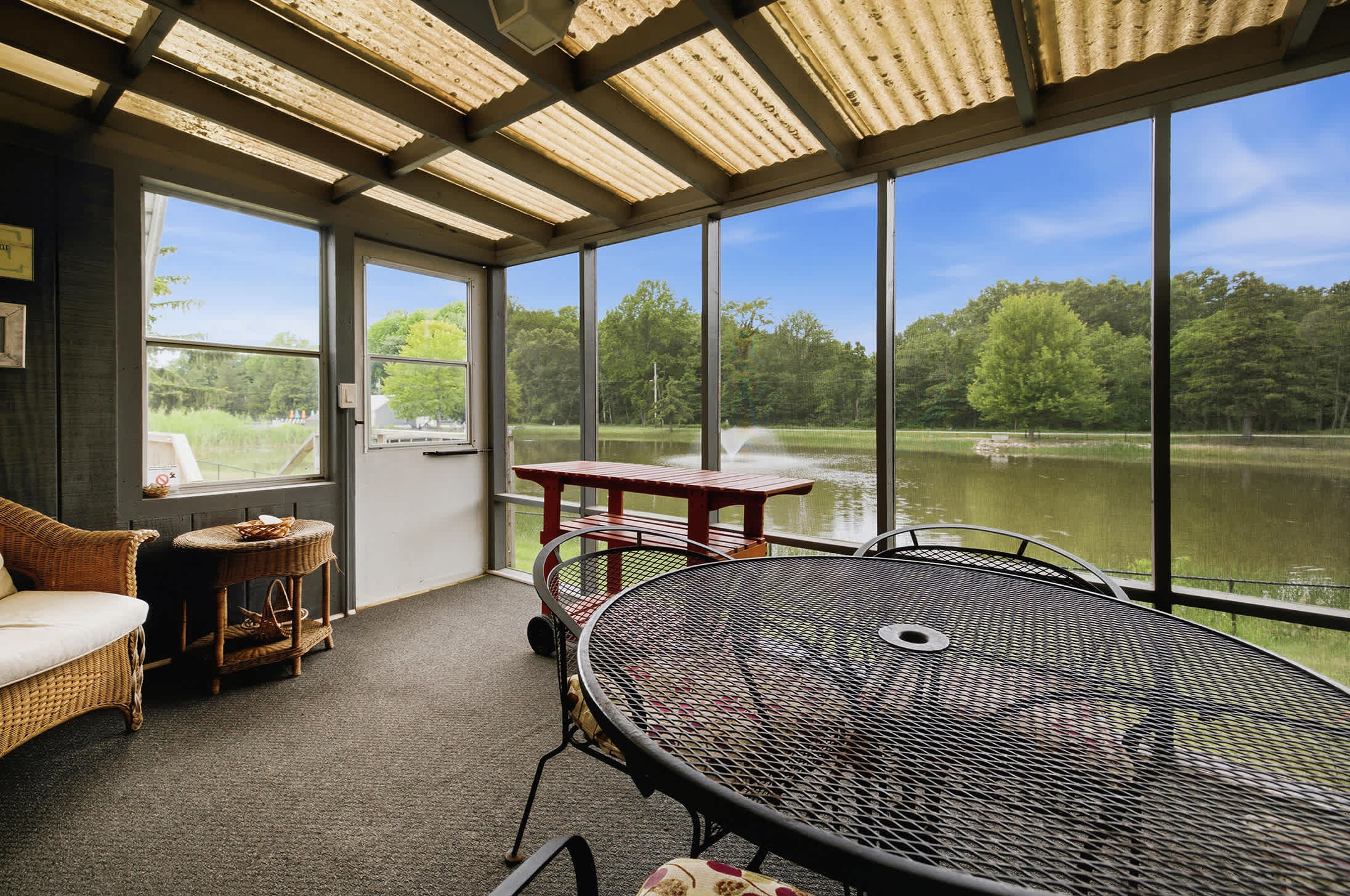 Chalet #93's screened porch overlooks the fishing pond, creating a comfortable outdoor space to dine, relax, and enjoy the view.