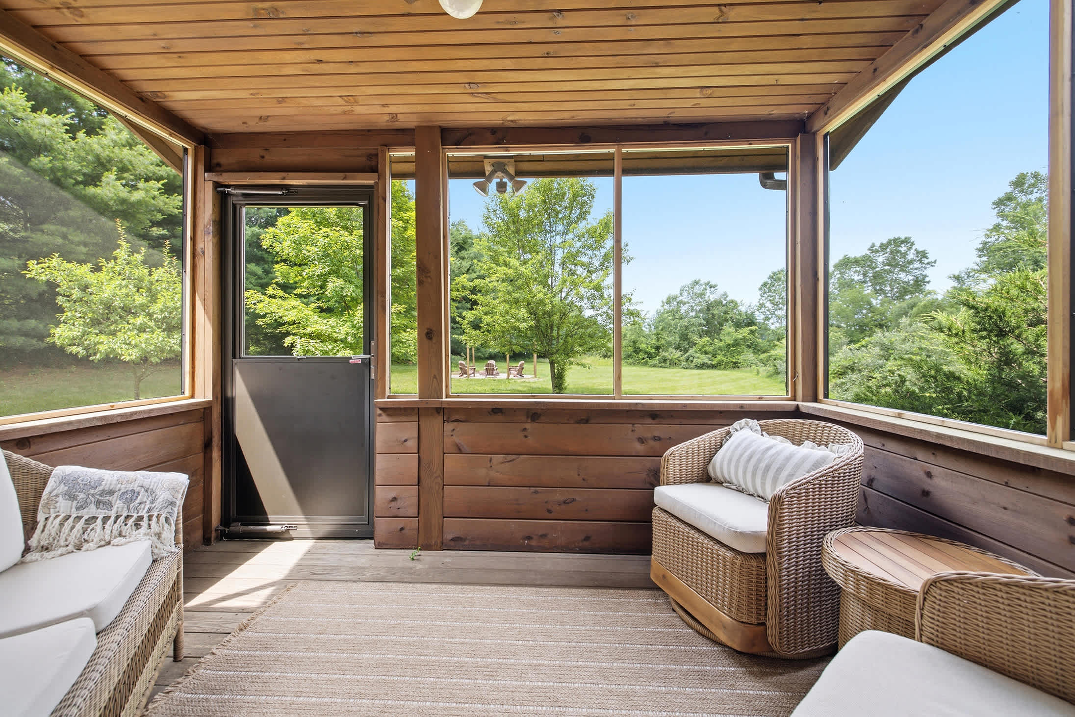 Wraparound windows, comfy wicker, and a green view in every direction.
