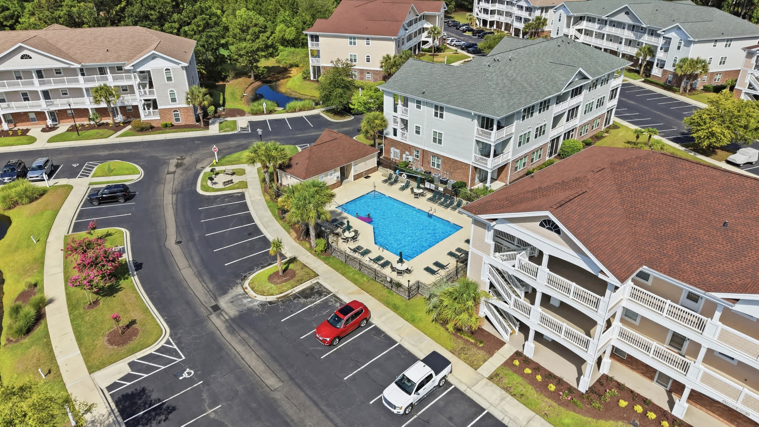 Neighborhood Pool, Grill and Shuttle Stop Next to Condo (grey roof)