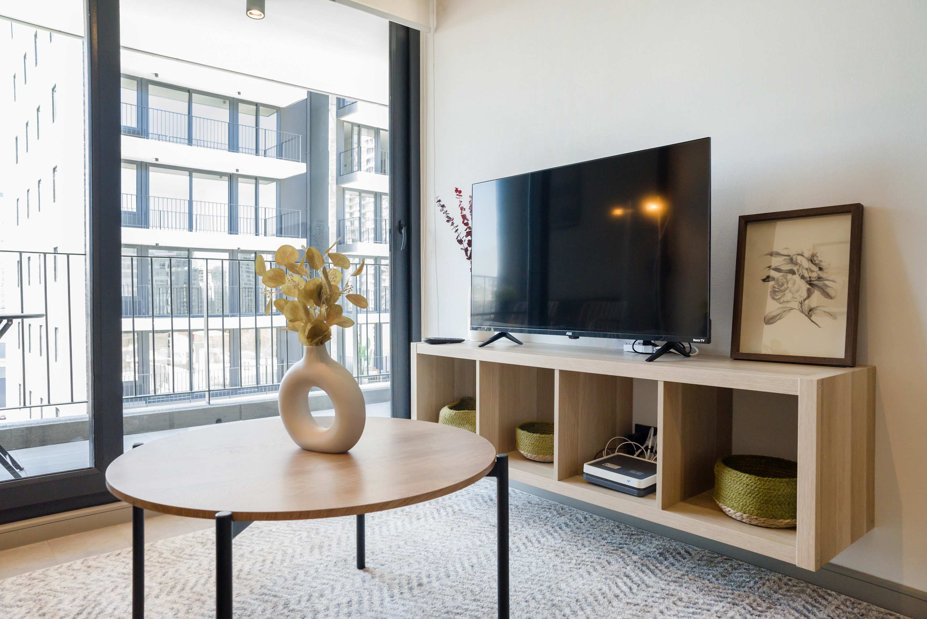 Bright and modern living area with a large TV and stylish decor, perfect for relaxation.