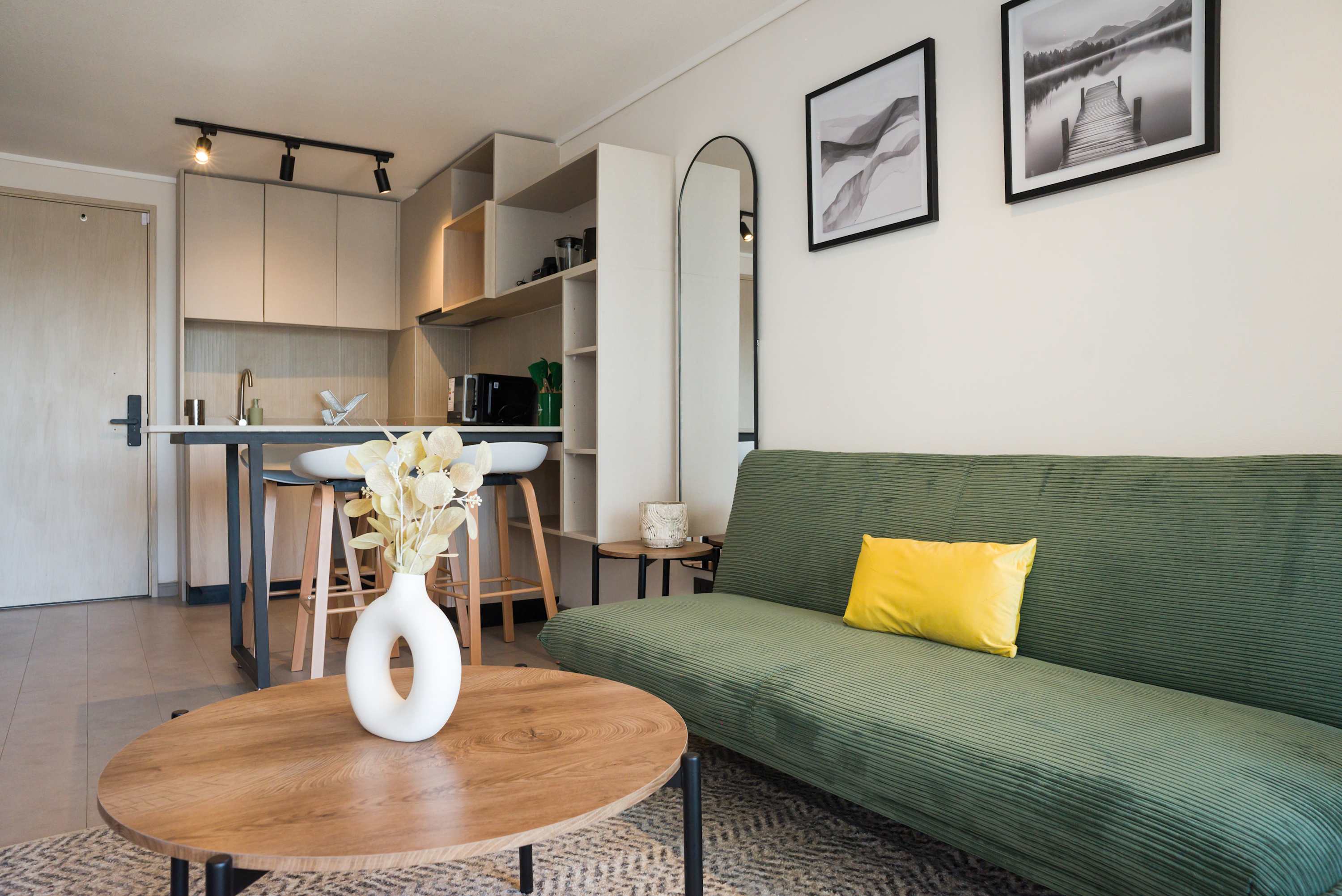 Cozy studio living area with stylish decor and a functional kitchenette, perfect for a relaxing stay.