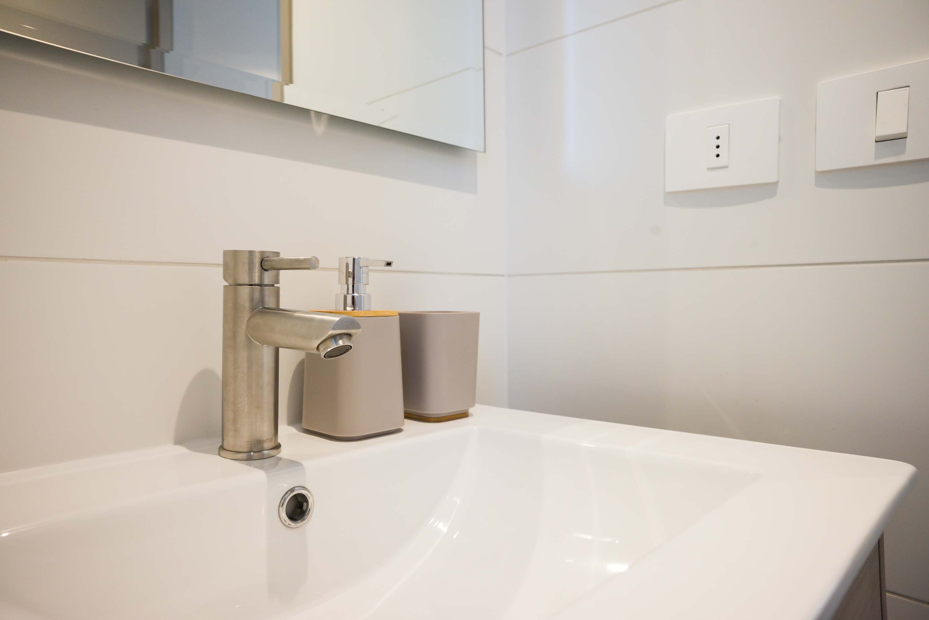 Experience modern elegance with this sleek bathroom design, featuring a stylish faucet and ample lighting.