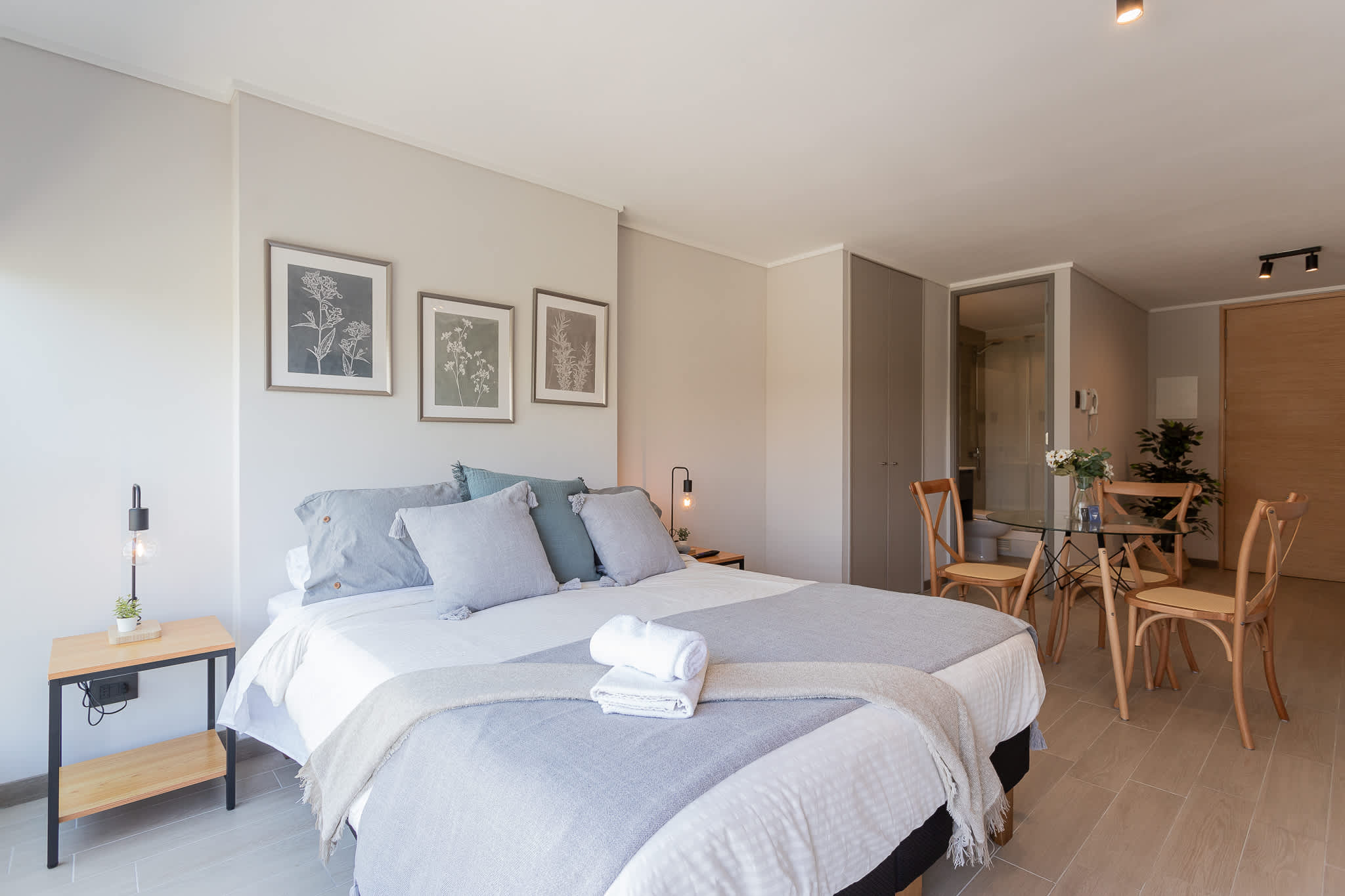 Experience modern comfort in this stylish studio with cozy bedding and a charming dining area.