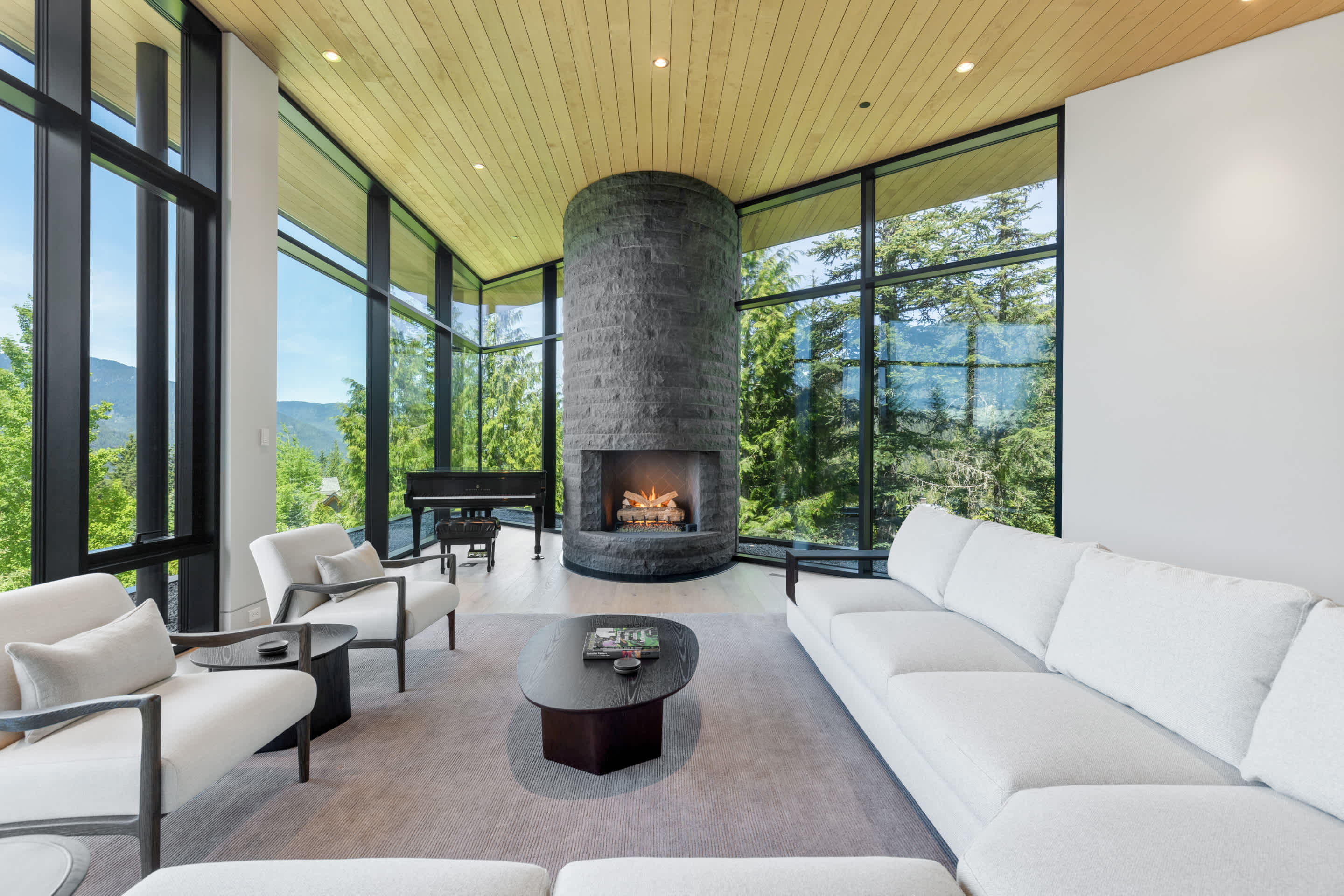 - Expansive living room with floor-to-ceiling mountain view windows - Cozy sectional seating bathed in natural light and open-concept design - Perfect blend of modern comfort and panoramic alpine scenery