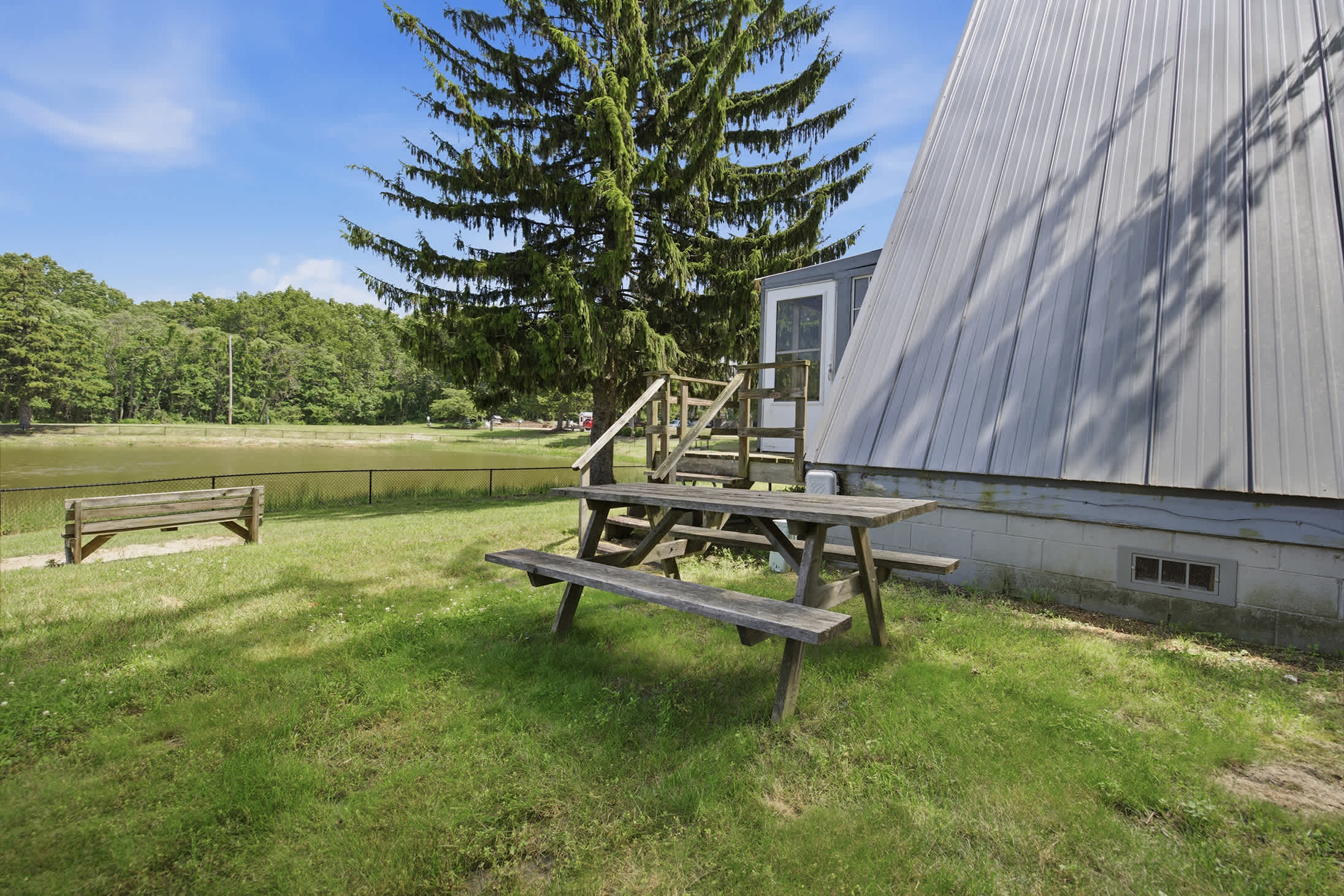 Step outside to a picnic table and open green space with relaxing views of the Chalet on the Lake pond.