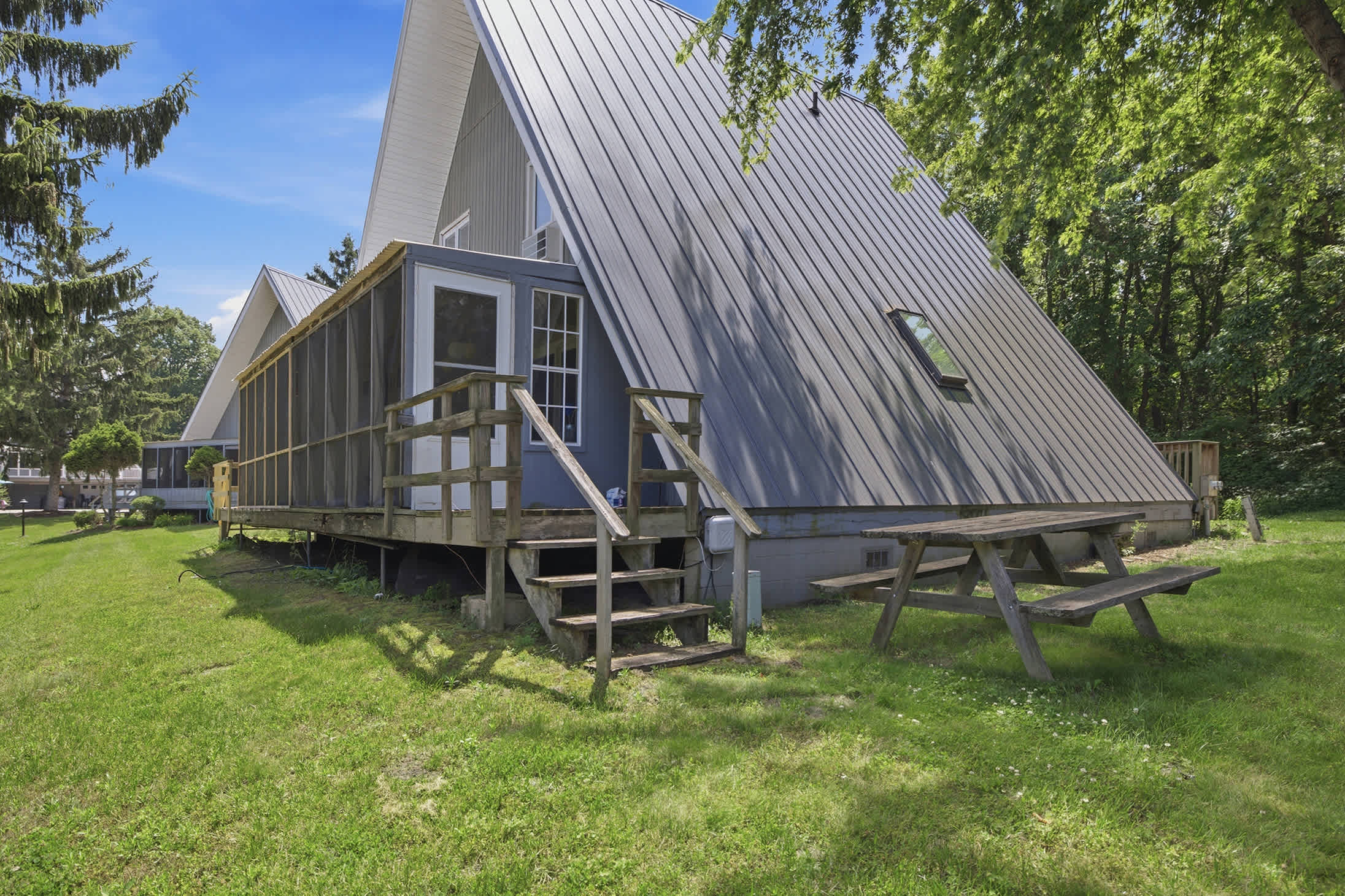 Chalet #95 features a screened porch, picnic area, and peaceful pond setting for easy outdoor living.