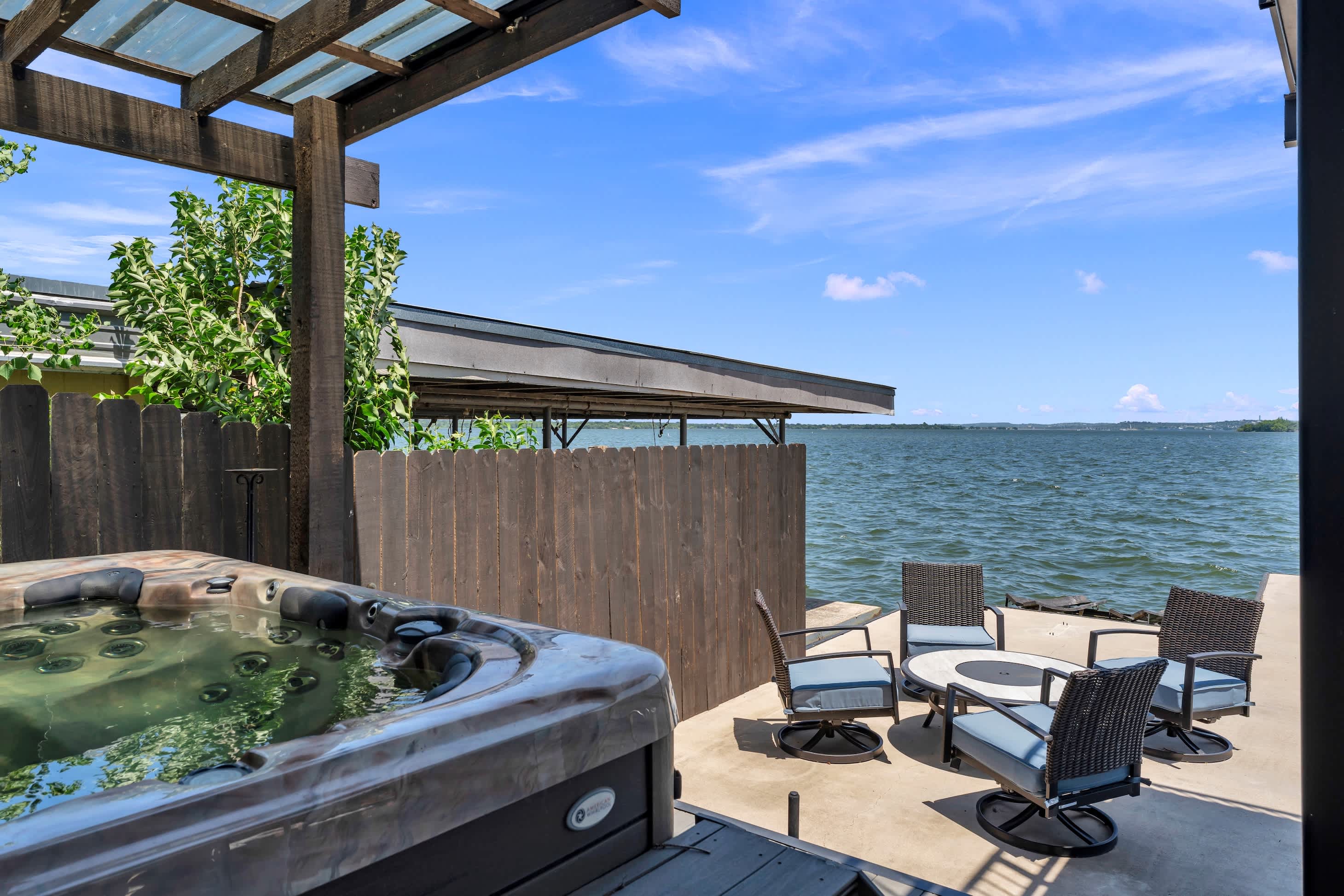 Lower level patio w/ hot tub, fire pit, & panoramic lake views