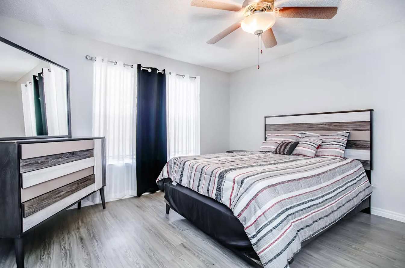 Relax in this cozy bedroom with modern furnishings and ample natural light.