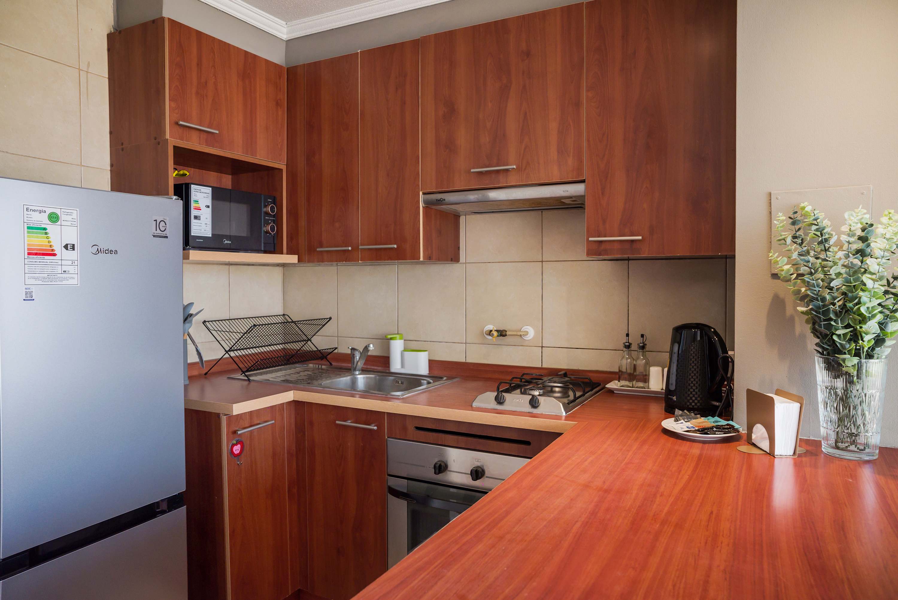 Cozy kitchen with modern appliances and warm wooden cabinetry, perfect for preparing meals during your stay.