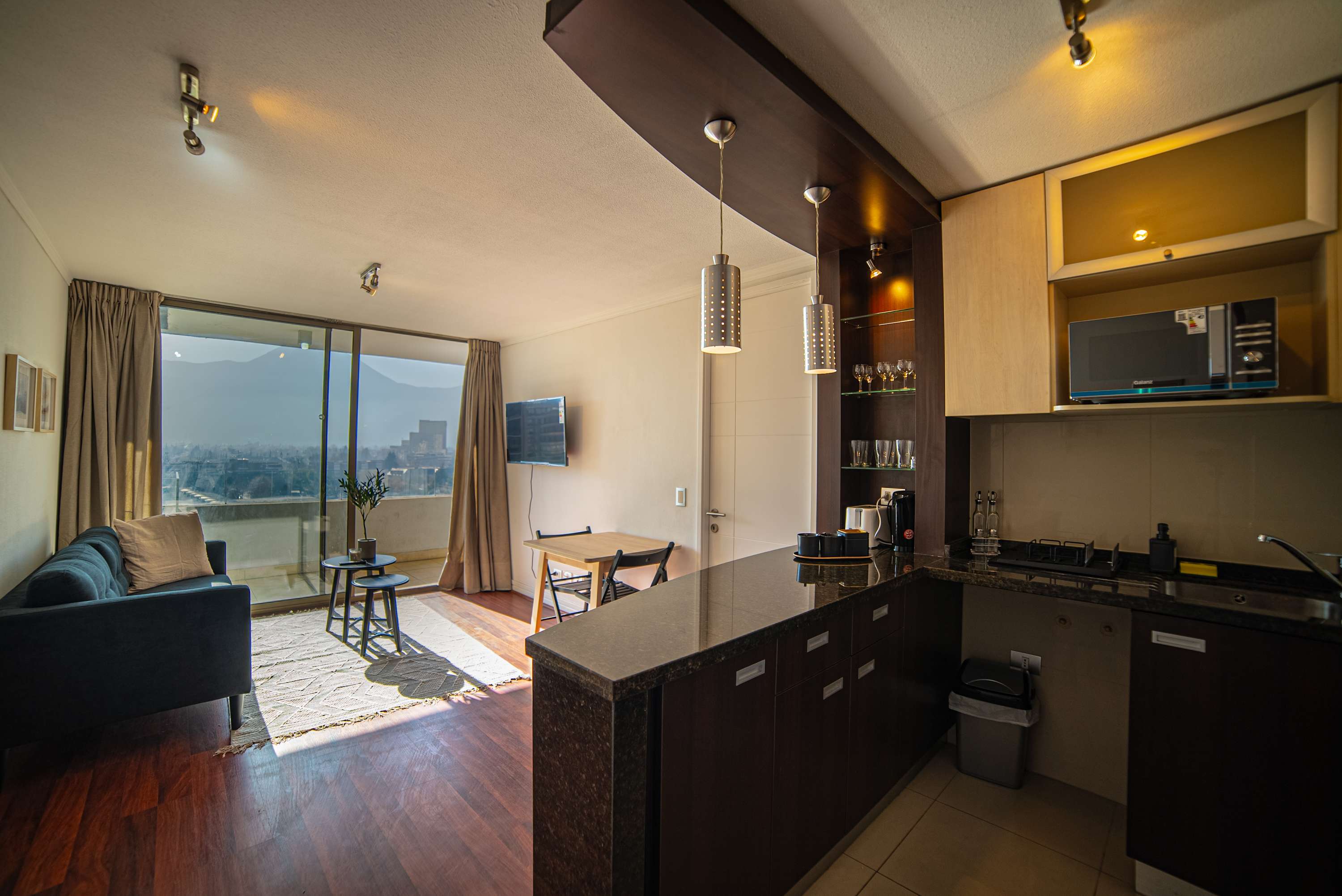 Enjoy stunning city views from this stylish studio apartment with a cozy living area and modern kitchen.