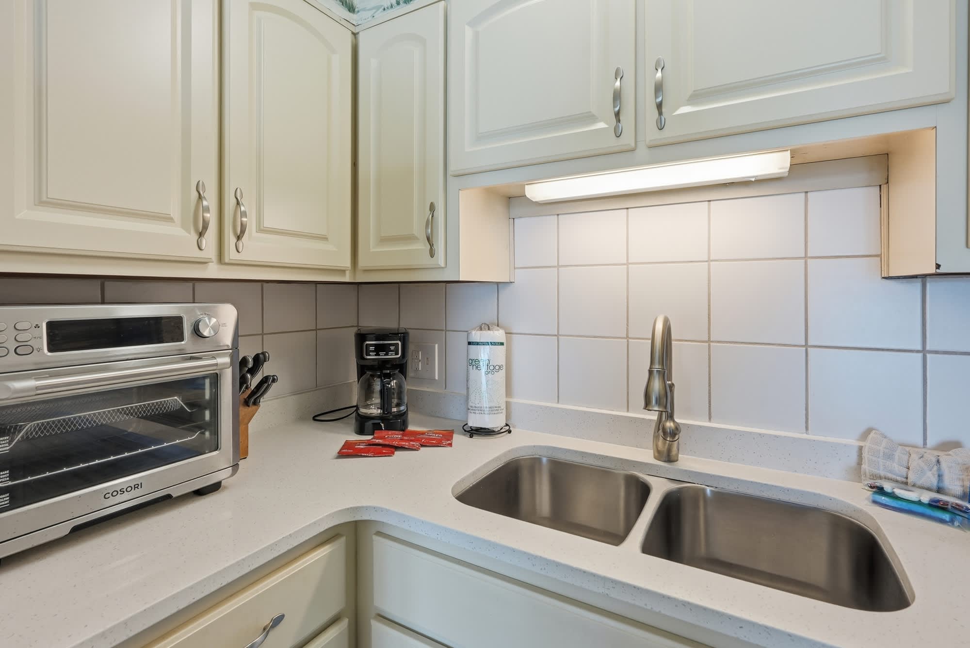 The Summit 830 – Kitchen with stainless steel appliances, double sink, coffee maker, and countertop.
