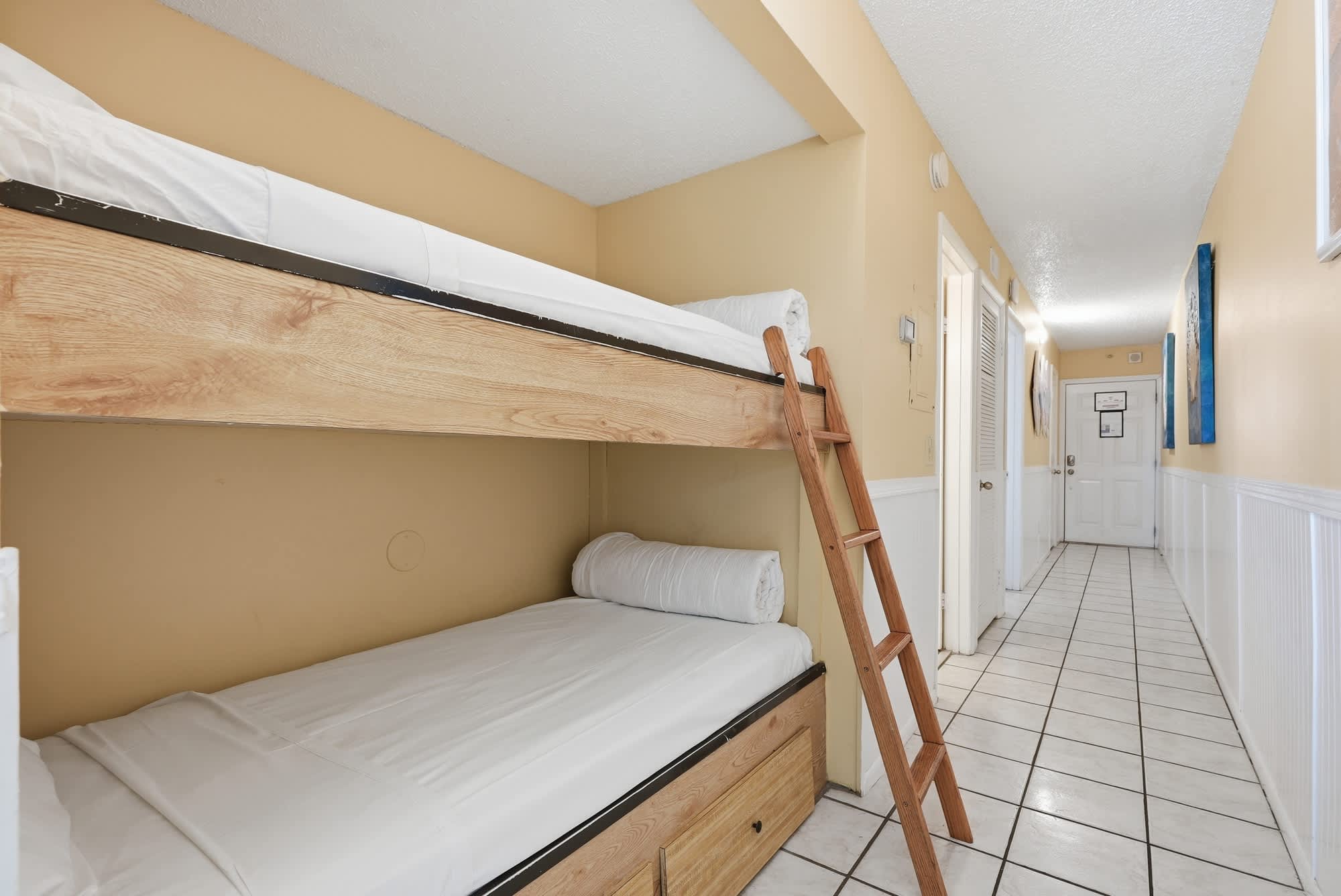 The Summit 830 – Bunk beds with a ladder in a hallway with tile flooring and beige walls.